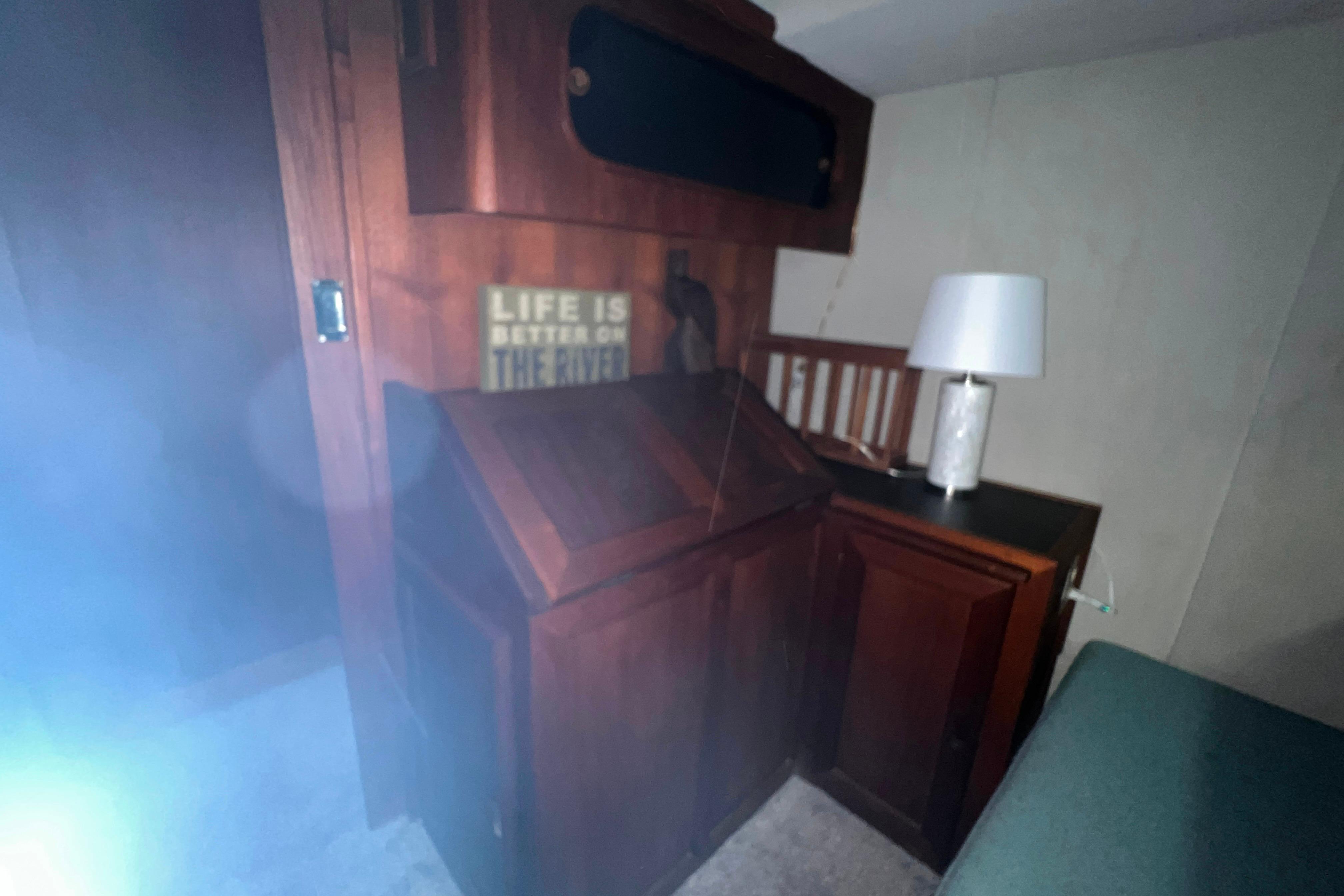 Interior of 1986 Bayliner 4550 Motoryacht with wooden cabinetry and lamp.