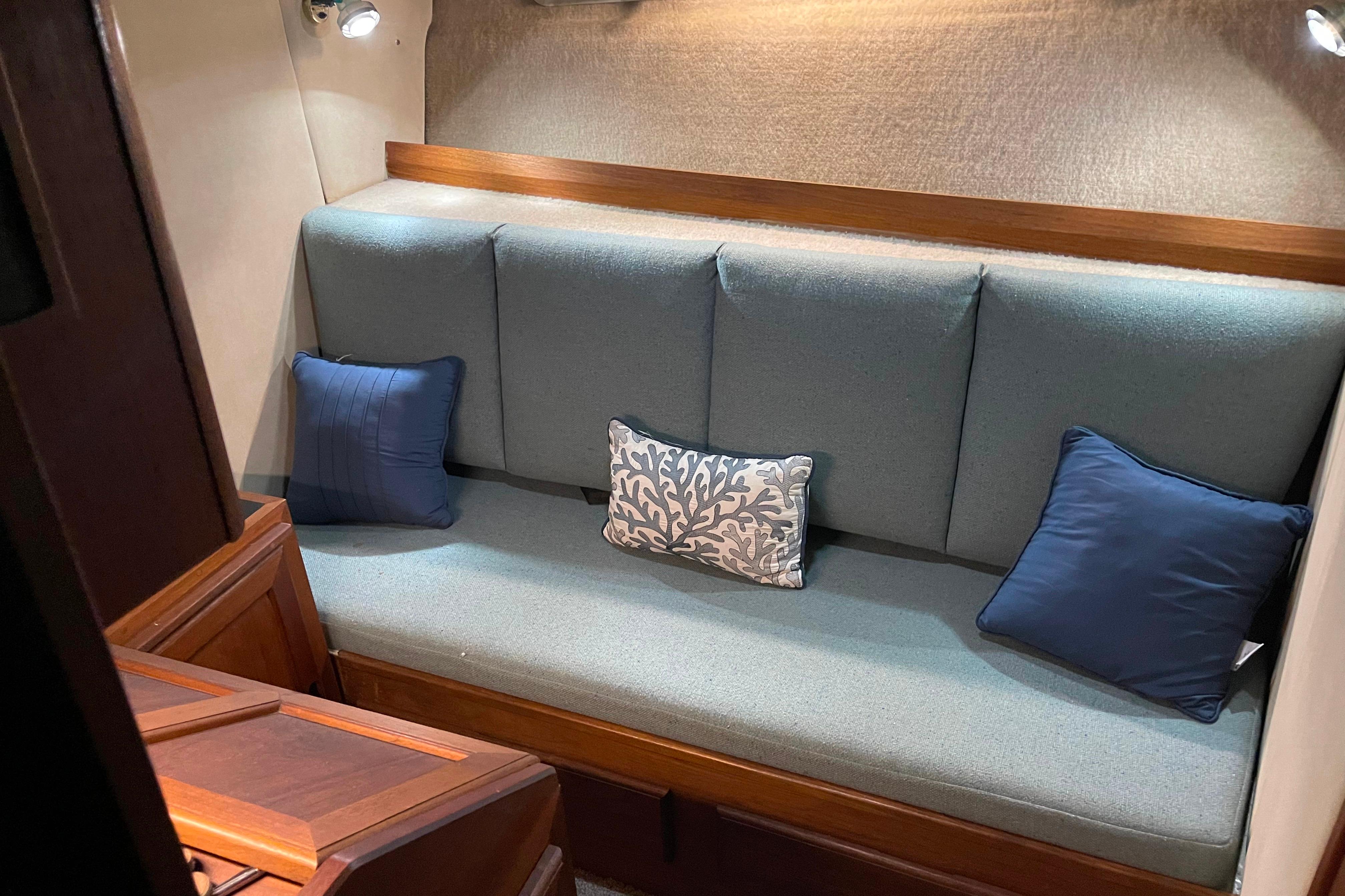 1986 Bayliner 4550 Motoryacht interior with cushioned seating and decorative pillows.