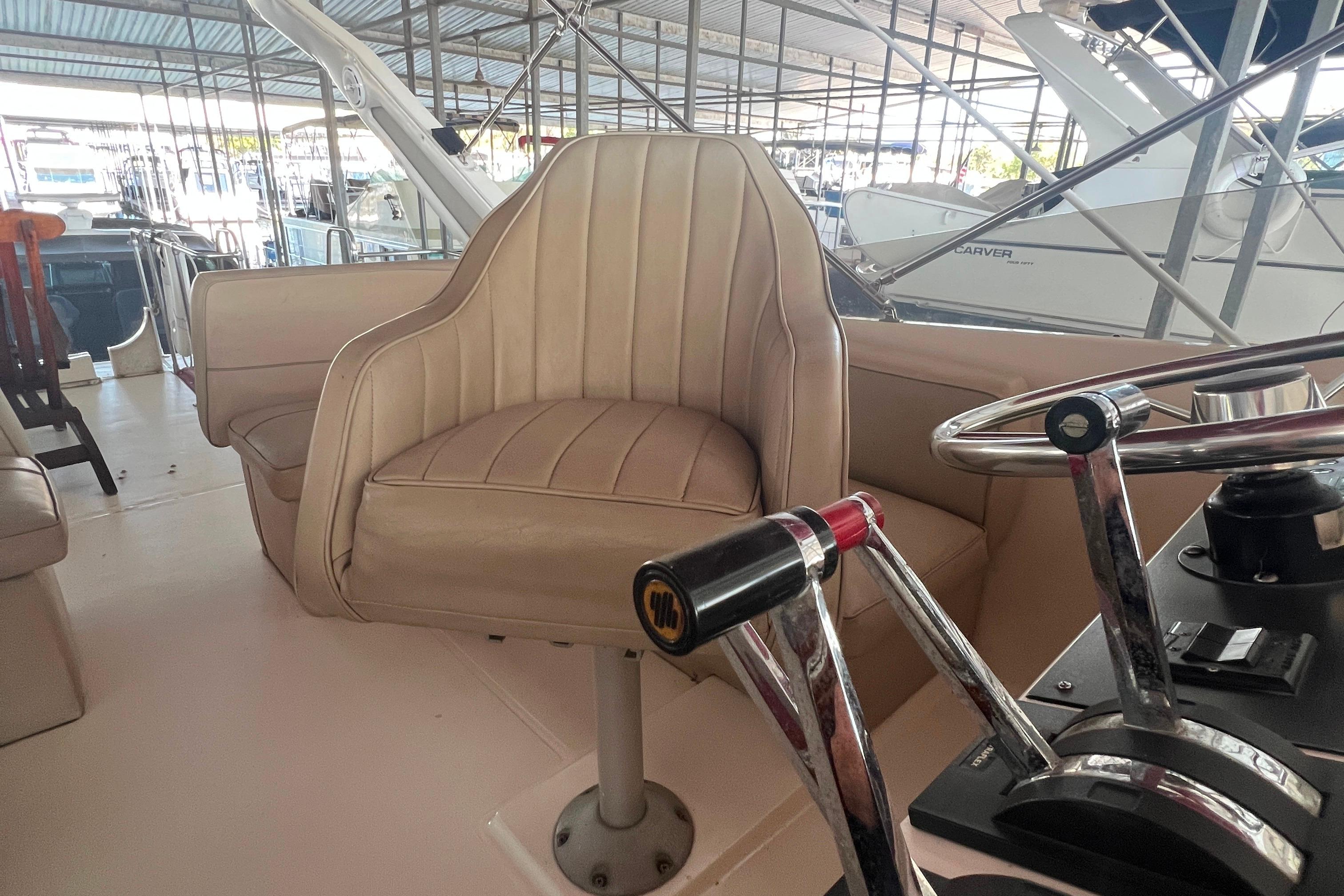 1986 Bayliner 4550 Motoryacht helm with beige captain's chair and steering controls.
