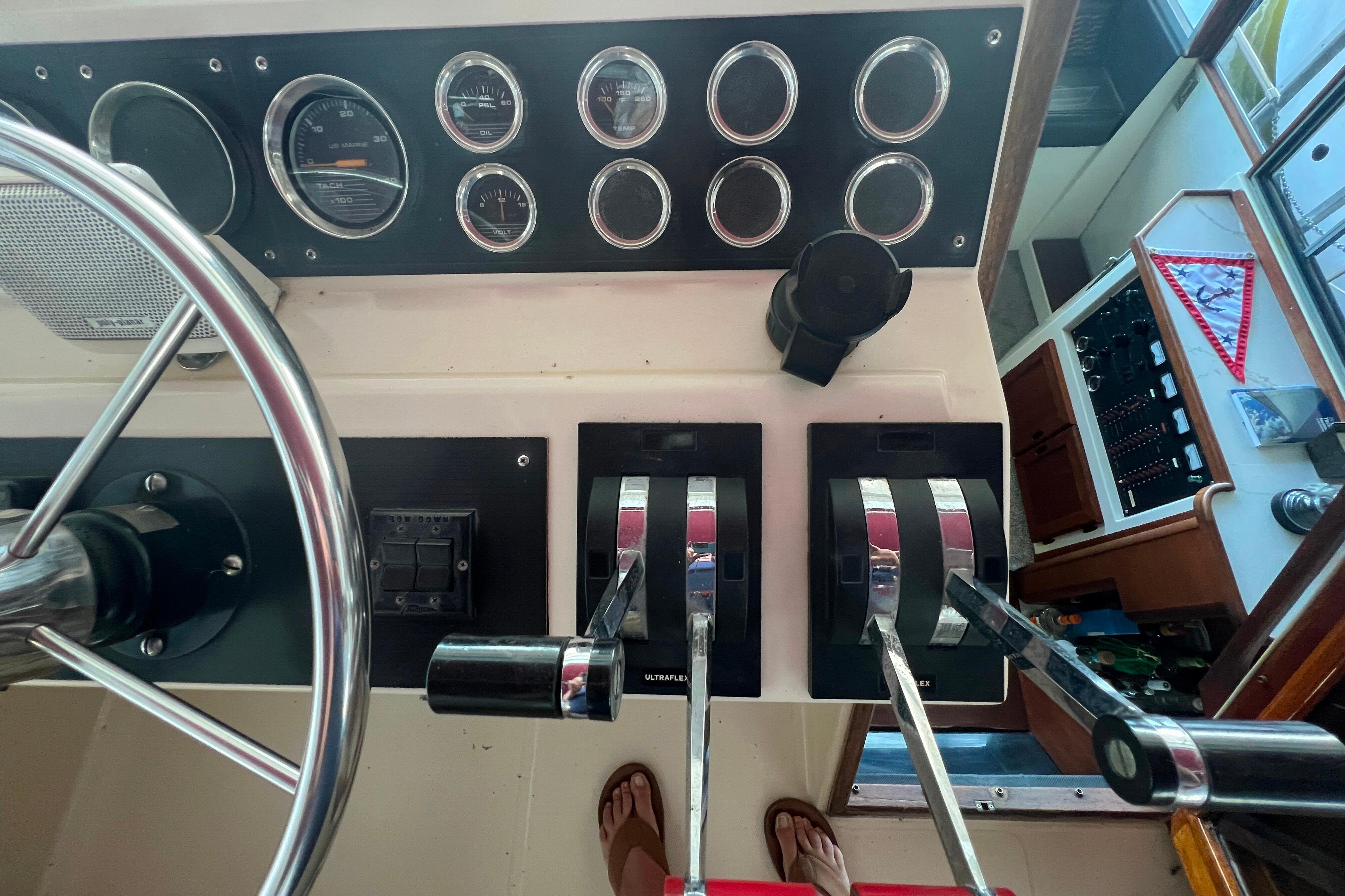 Control panel of a 1986 Bayliner 4550 Motoryacht with steering wheel and throttle levers.