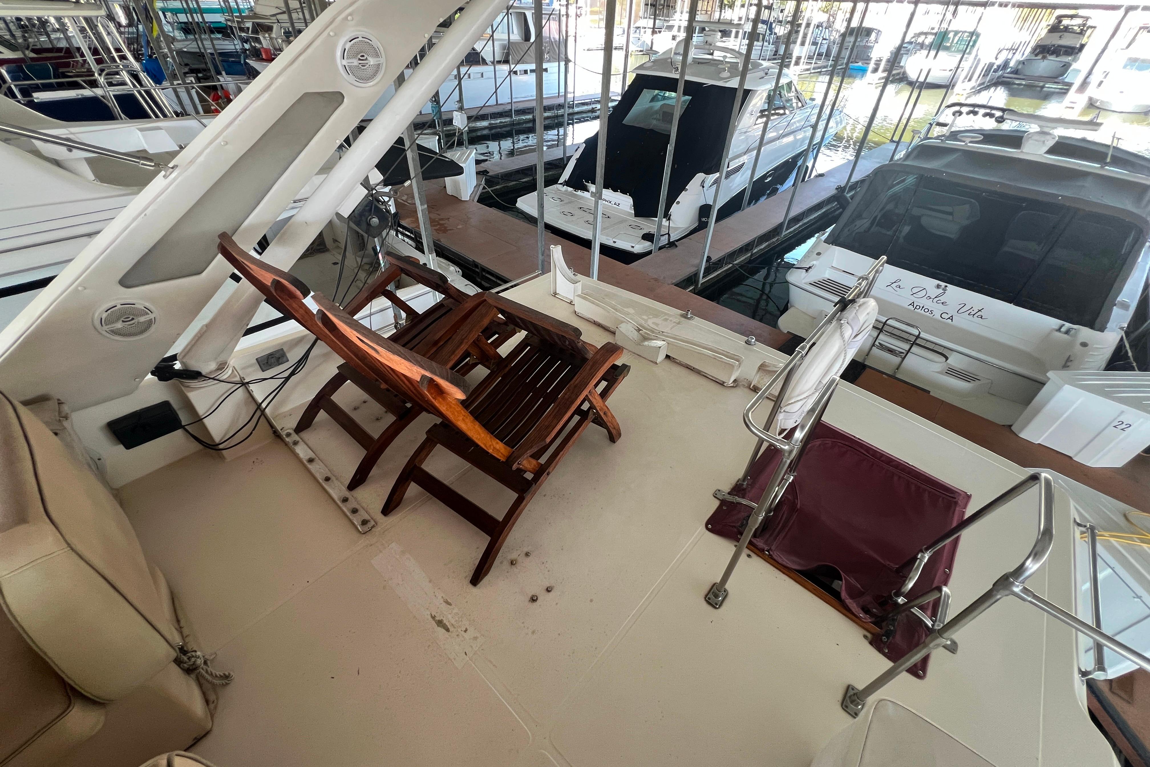 1986 Bayliner 4550 Motoryacht deck with wooden chair and marina view.