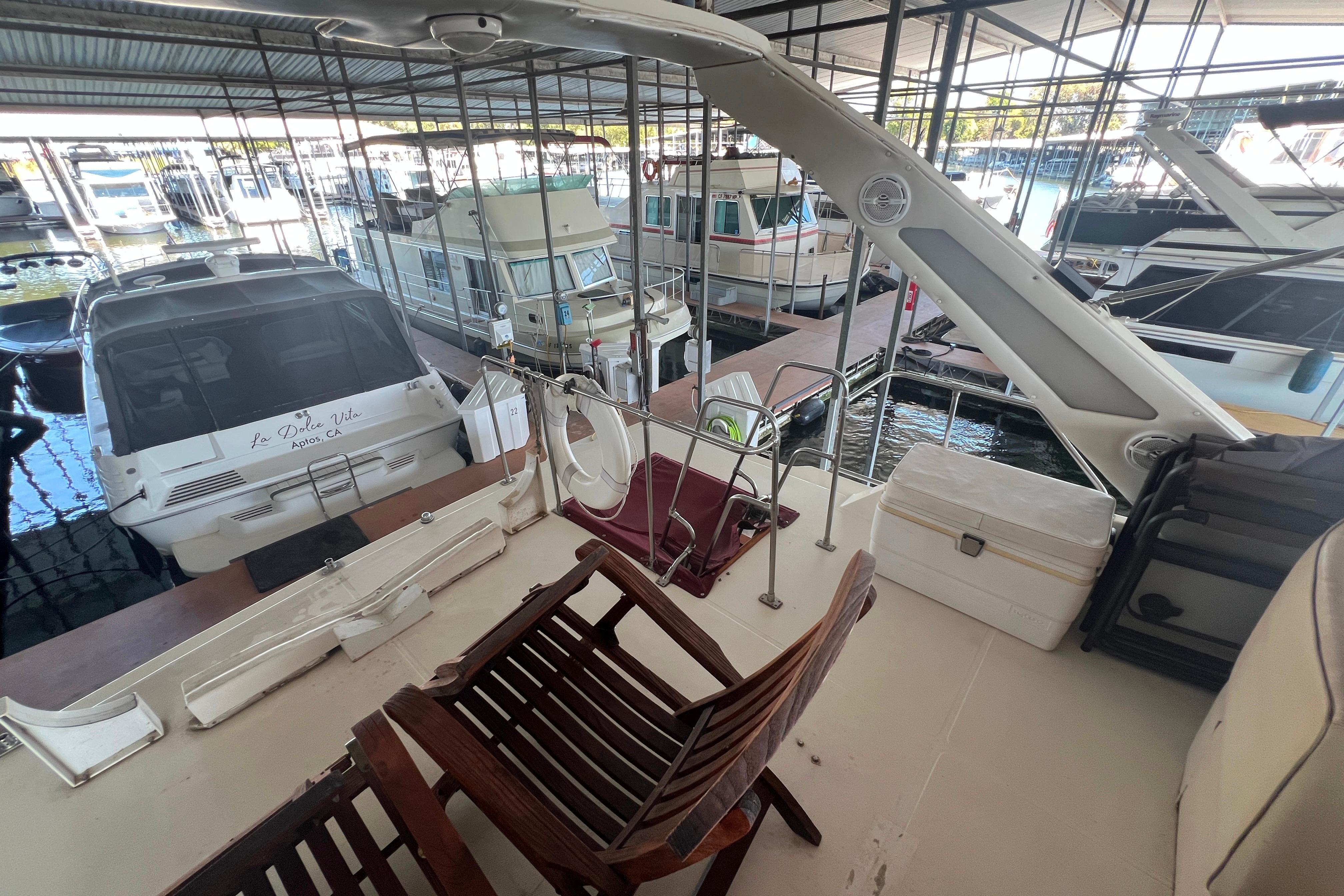 1986 Bayliner 4550 Motoryacht docked in marina, featuring spacious deck and seating area.