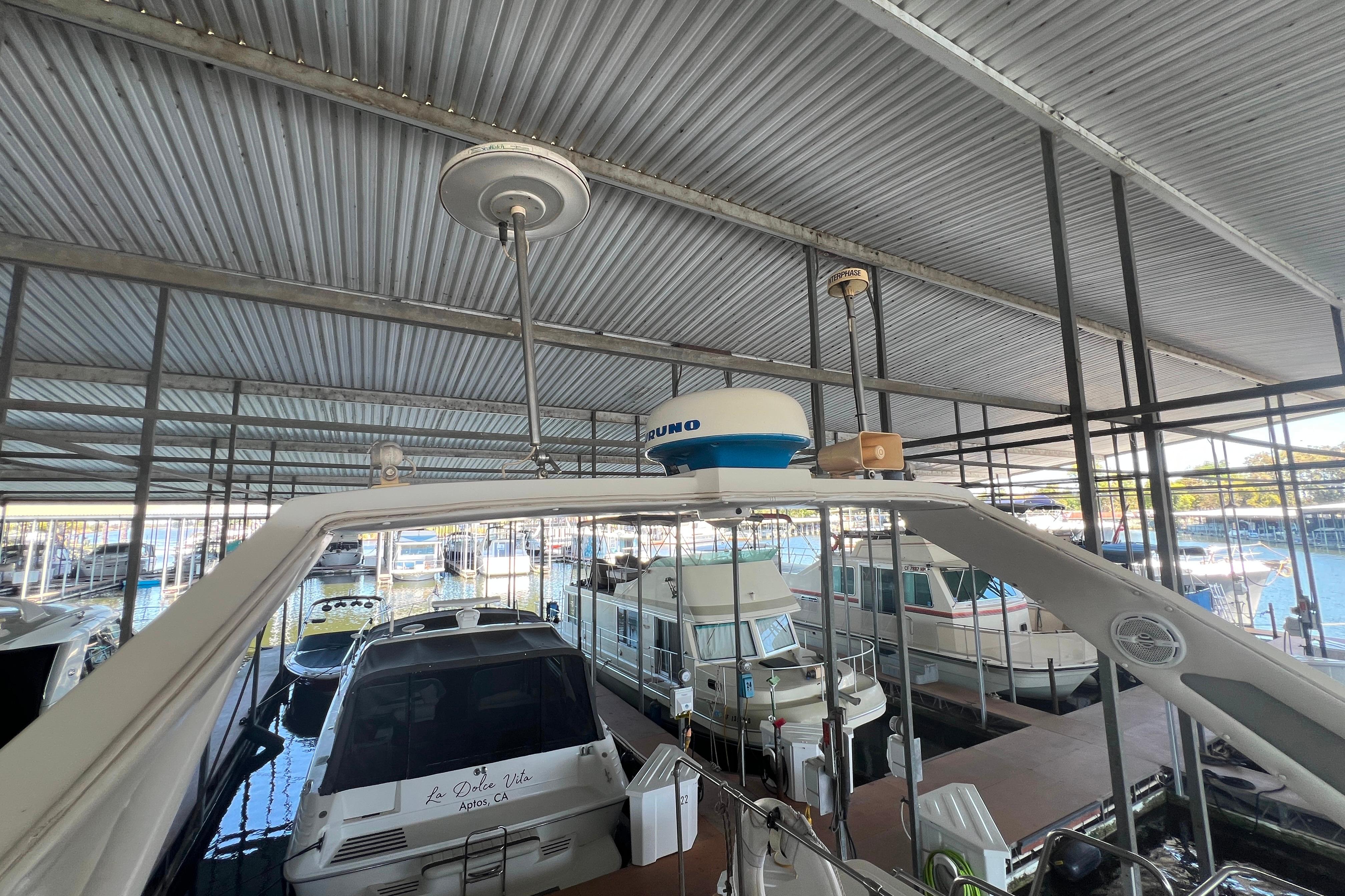 1986 Bayliner 4550 Motoryacht docked in a covered marina with other boats.