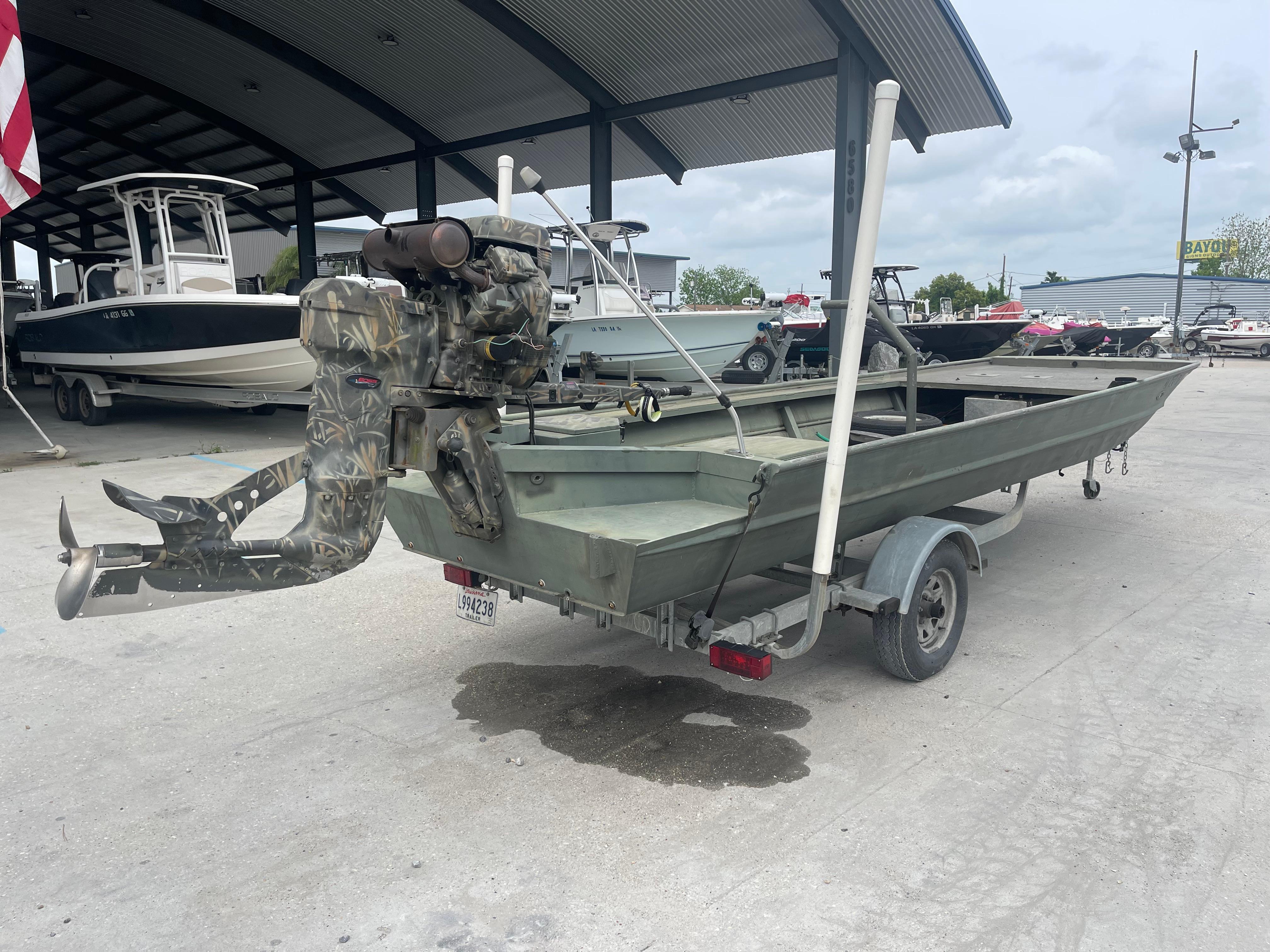 2016 WeldBilt 18x48 boat on trailer with camo outboard motor in marina.