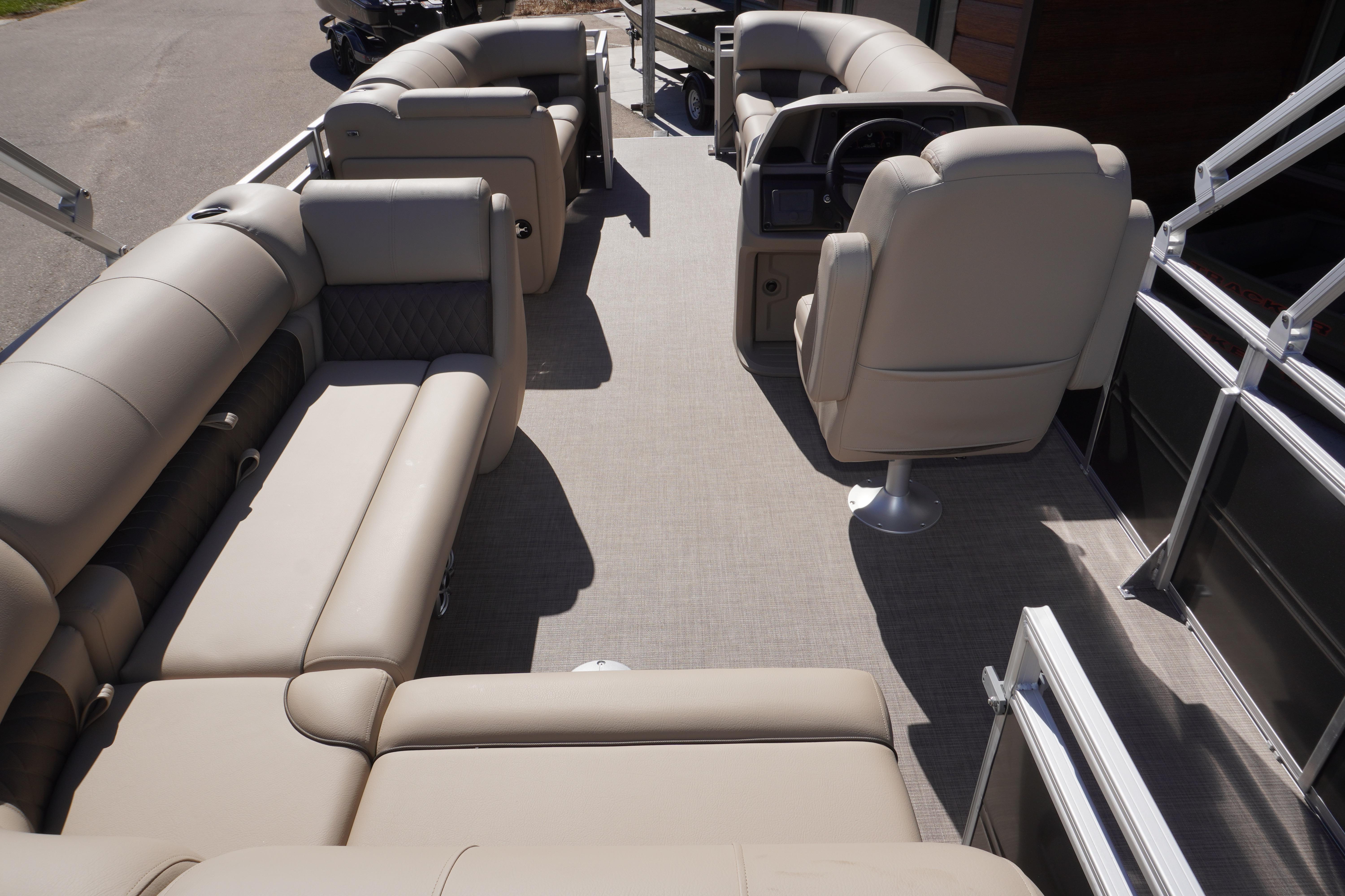 2024 Sun Tracker Party Barge 20 DLX interior with beige seating and helm.