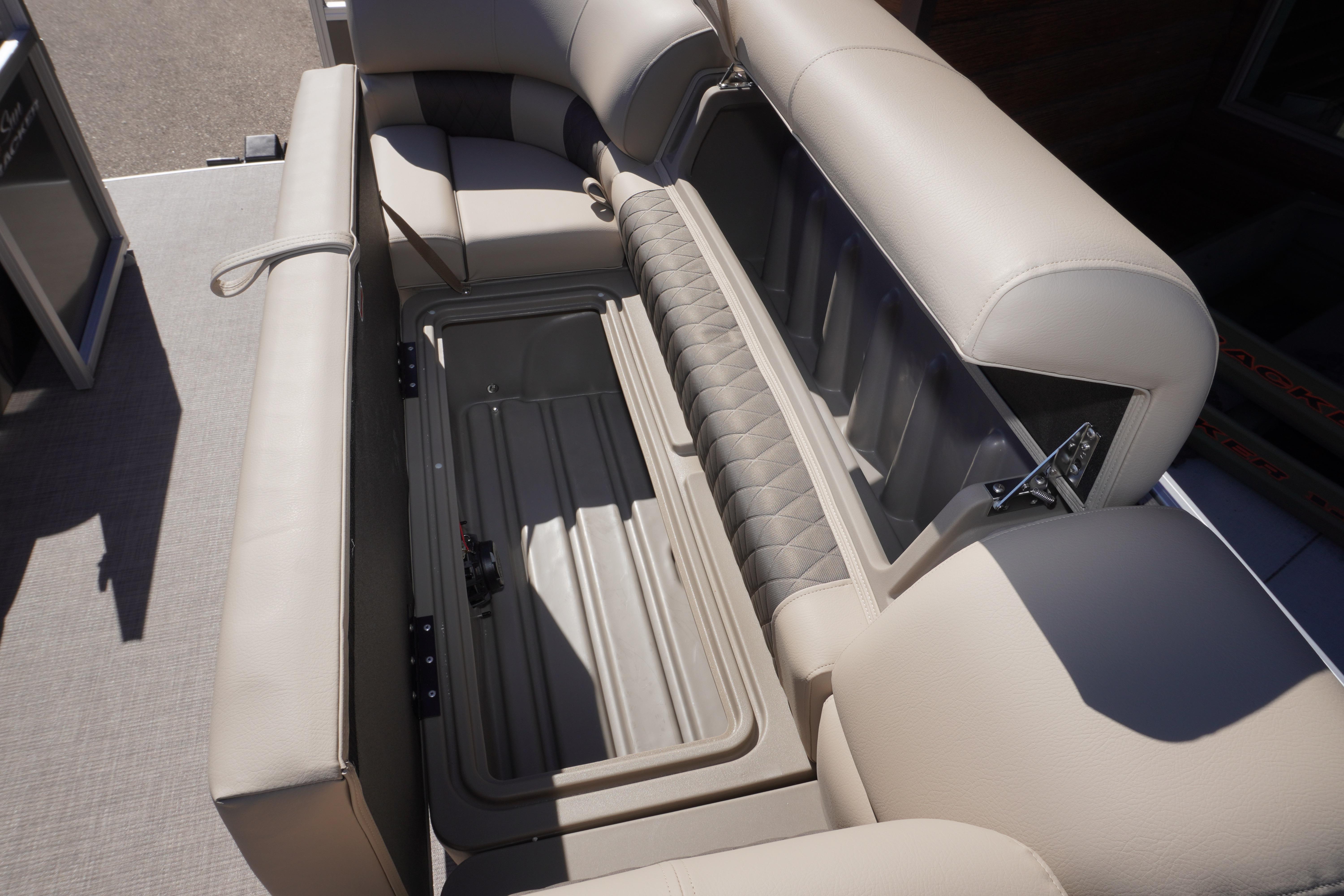 2024 Sun Tracker Party Barge 20 DLX interior storage compartment with beige seating.