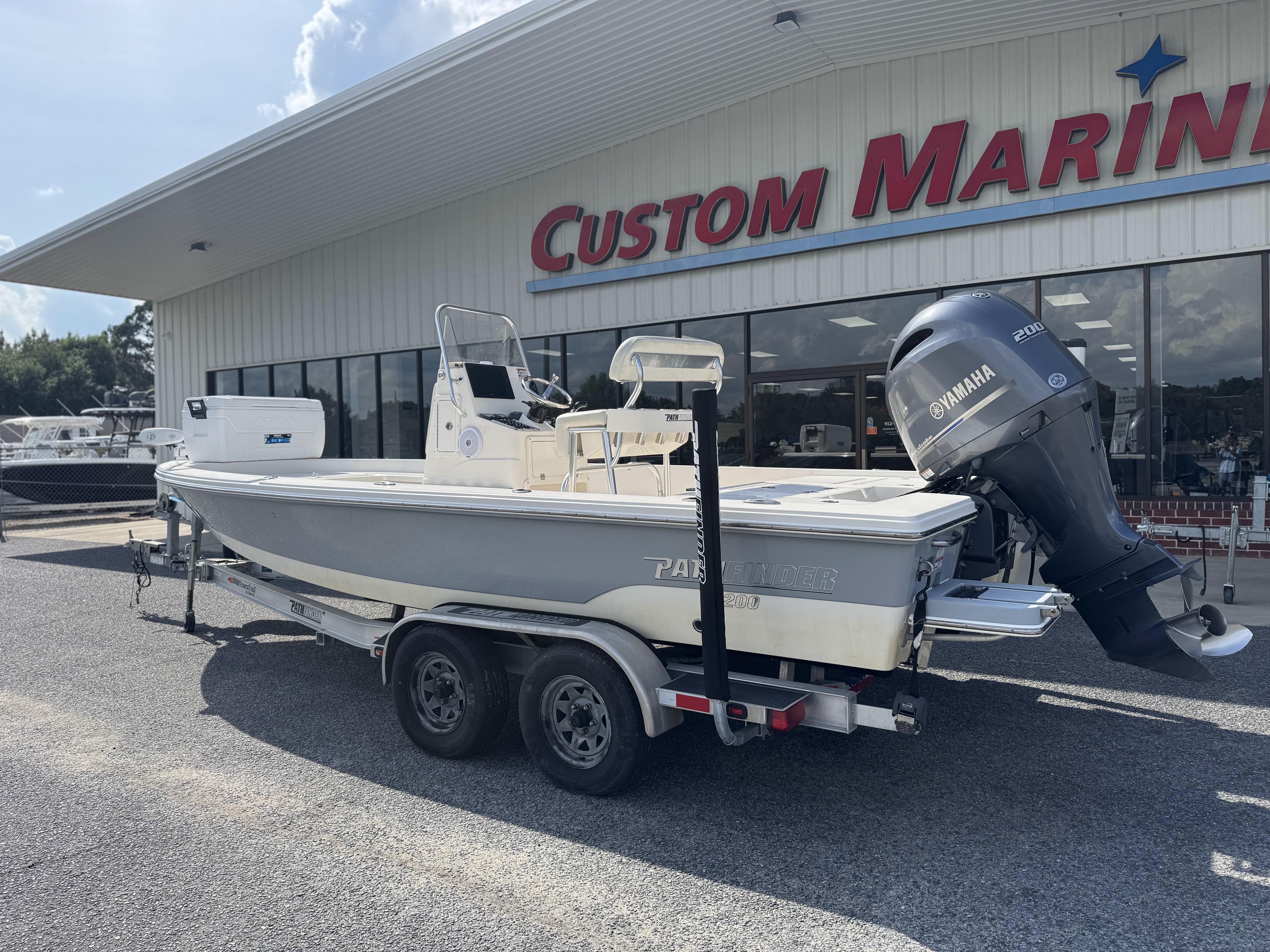 2014 Pathfinder 2200 TRS boat on trailer outside Custom Marine dealership.