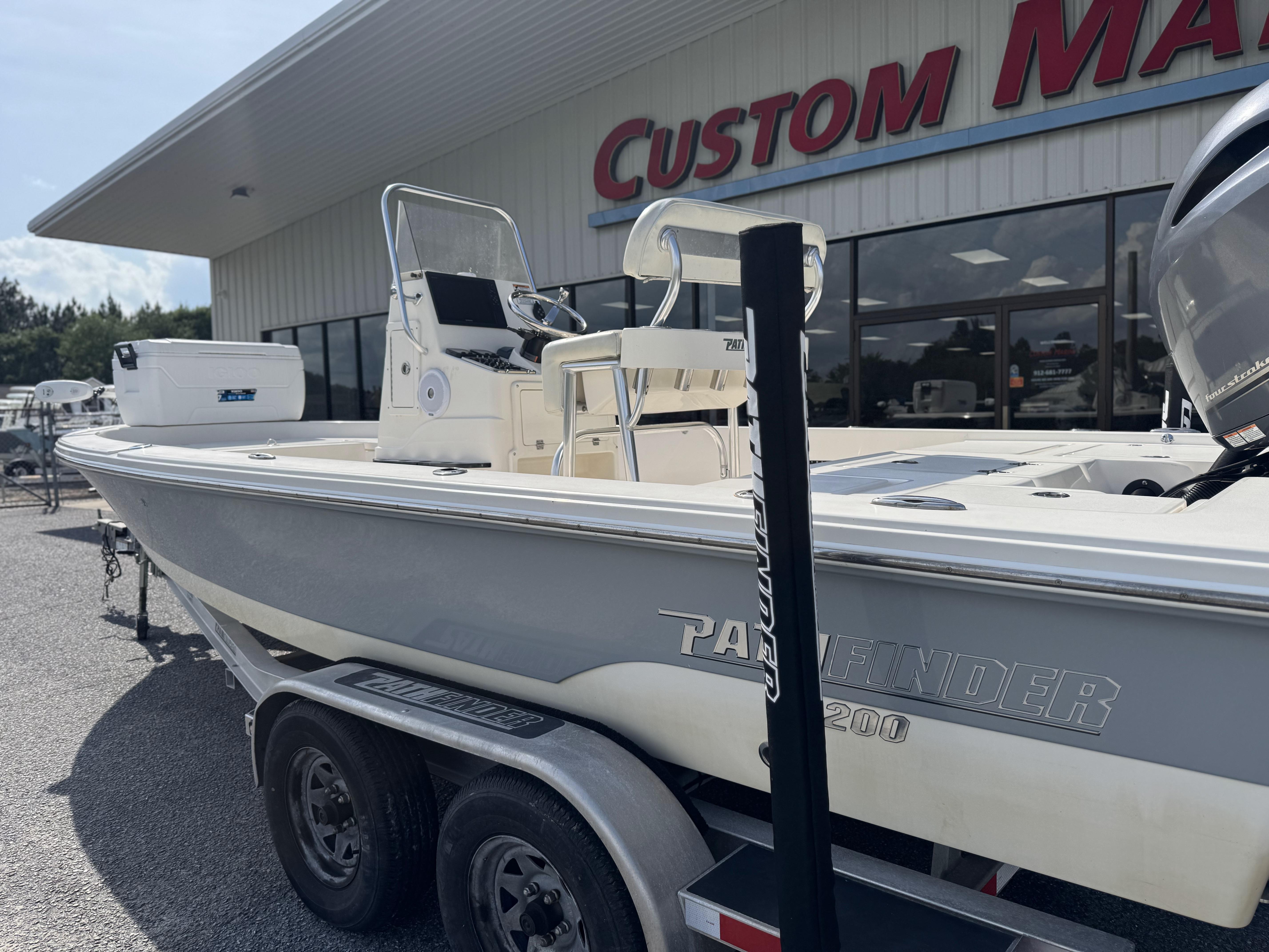 2014 Pathfinder 2200 TRS boat on trailer outside Custom Marine dealership.