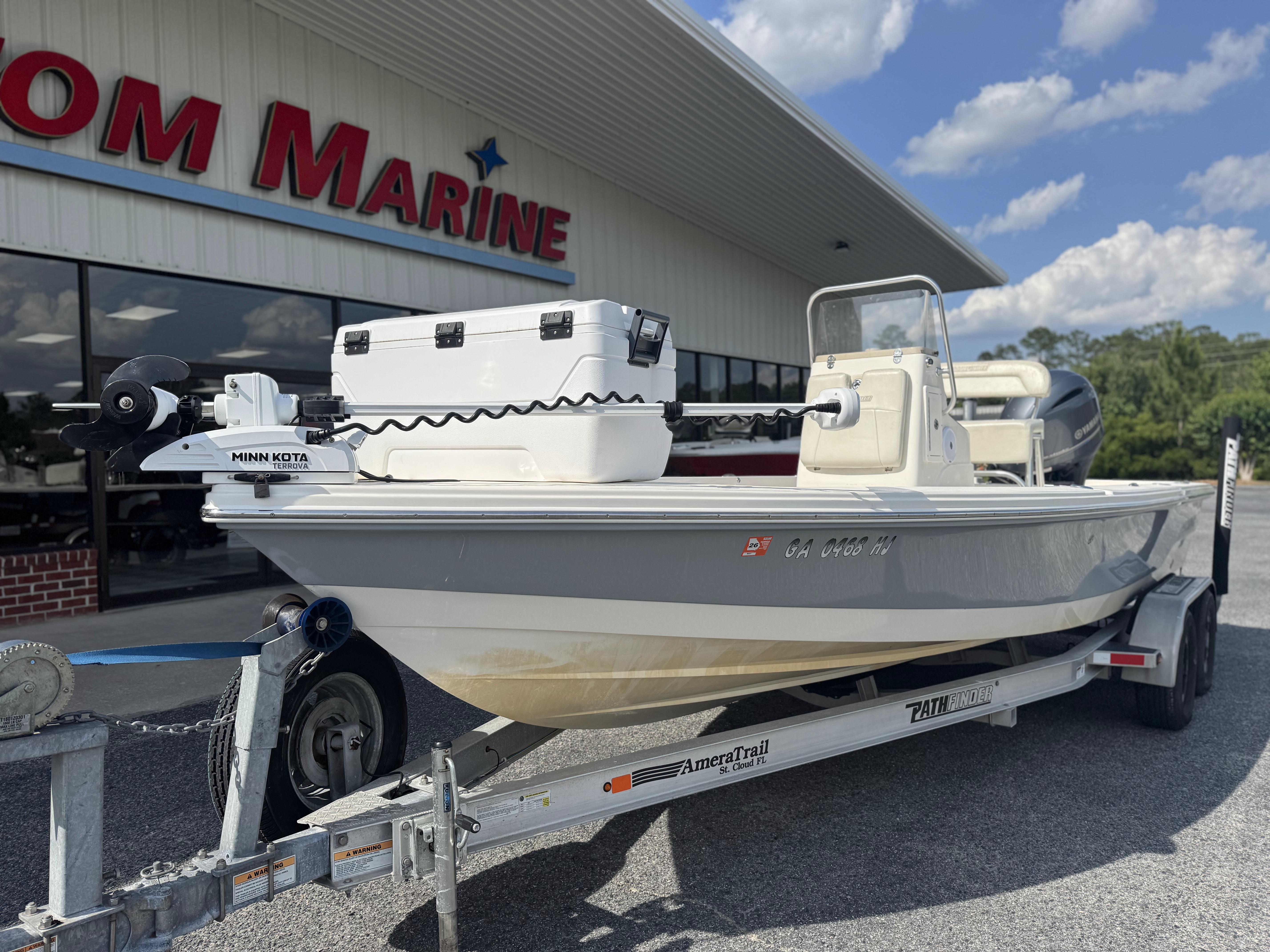 2014 Pathfinder 2200 TRS boat on trailer outside marine dealership.
