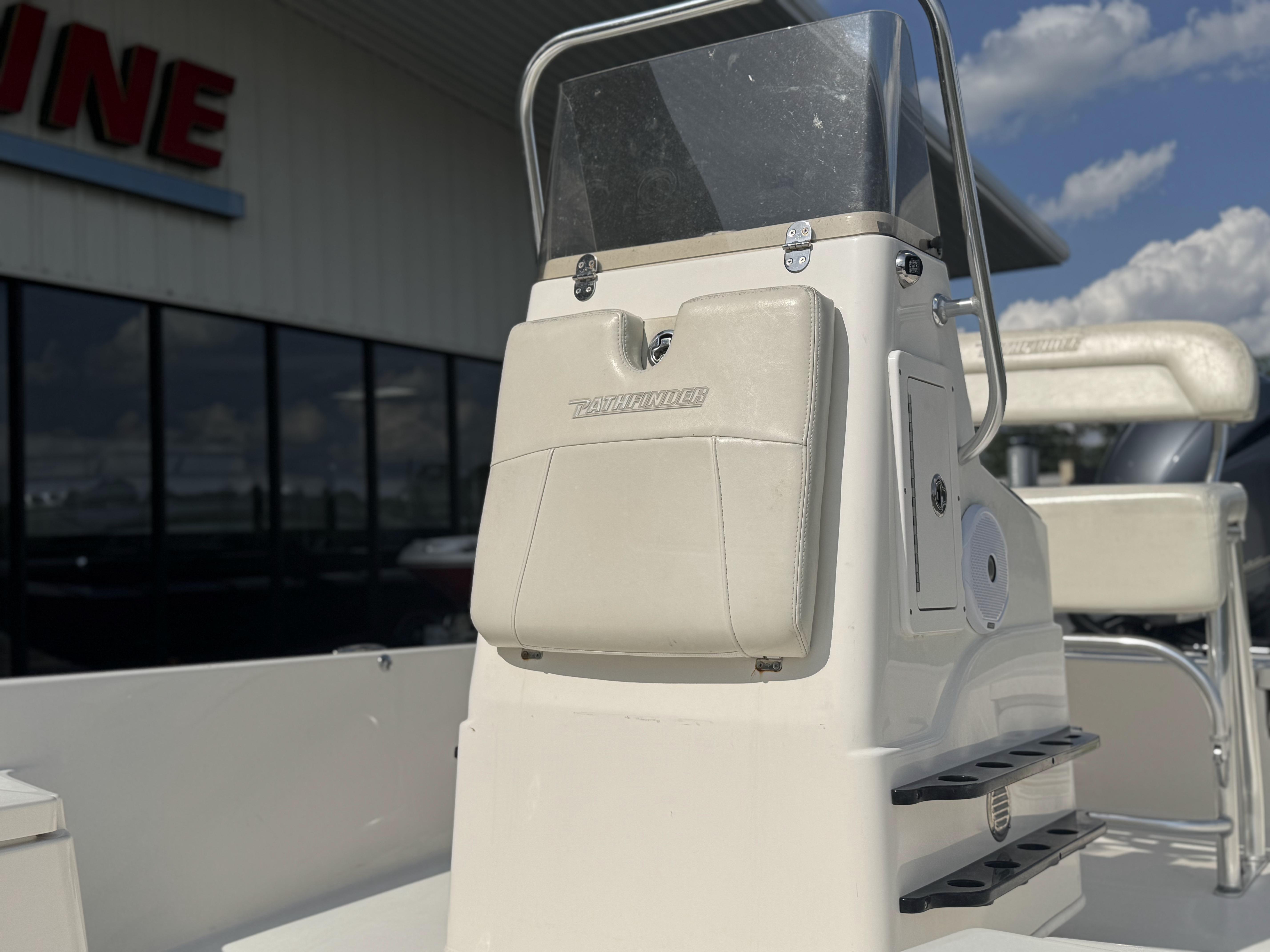 2014 Pathfinder 2200 TRS boat console with windshield, outdoors under a blue sky.