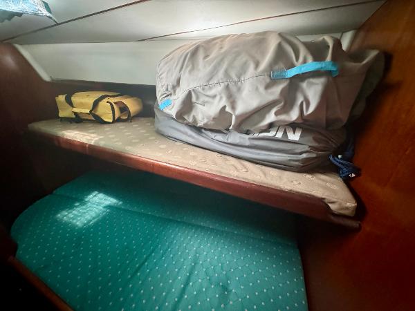 Beneteau Oceanis 40 CC 1996 cabin with storage bags on a wooden shelf.