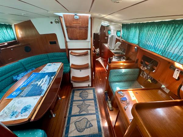 Interior of 1996 Beneteau Oceanis 40 CC sailboat with wood finish and green upholstery.