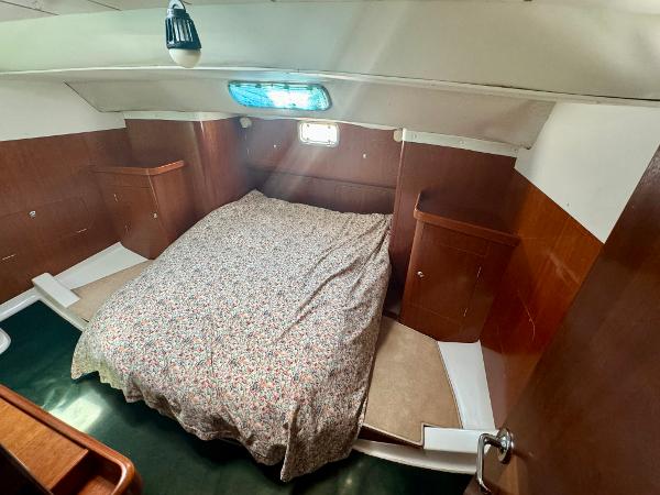 1996 Beneteau Oceanis 40 CC cabin interior with bed and wooden cabinetry.