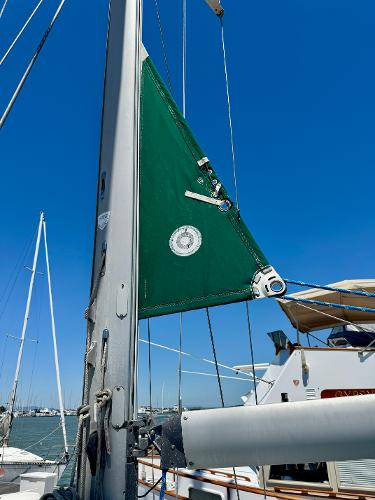 Sailboat mast and sail detail on 1996 Beneteau Oceanis 40 CC under clear blue sky.