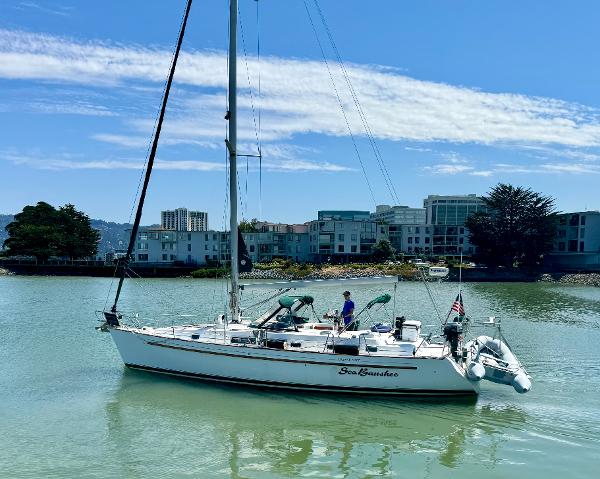 Beneteau Oceanis 40 CC sailboat from 1996 on calm water near urban buildings.