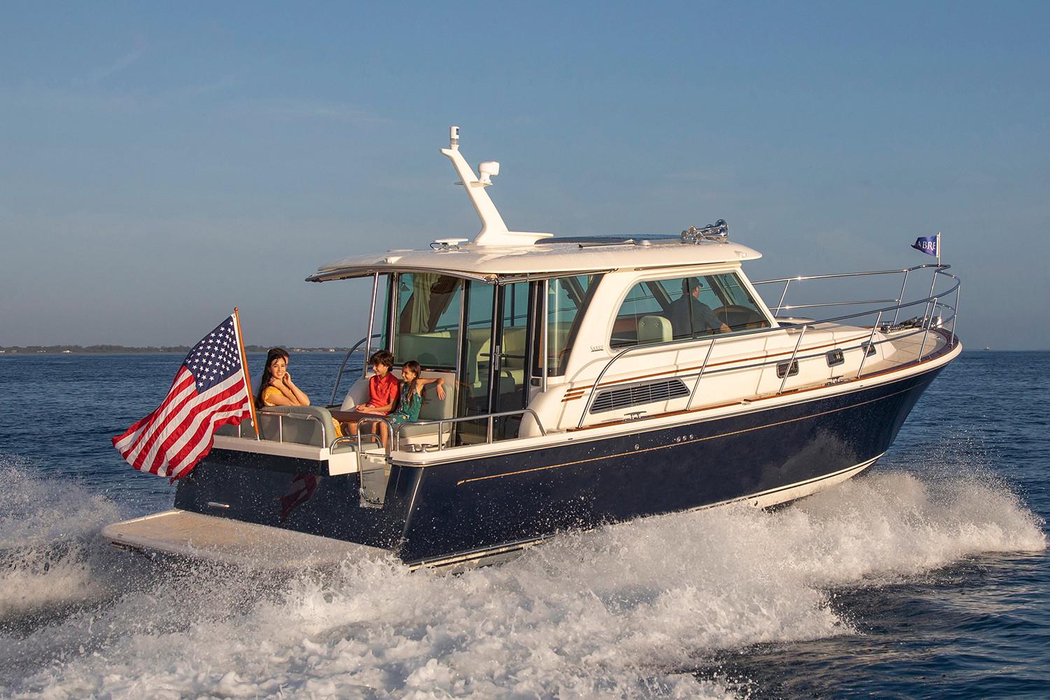 Manufacturer Provided Image: 2026 Sabre 38 Salon Express cruising with passengers, American flag waving, on open water.