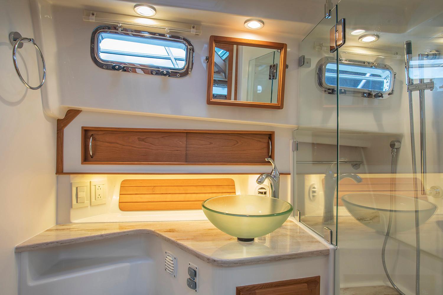 Manufacturer Provided Image: Luxurious bathroom interior of 2026 Sabre 38 Salon Express yacht with glass sink and wooden accents.