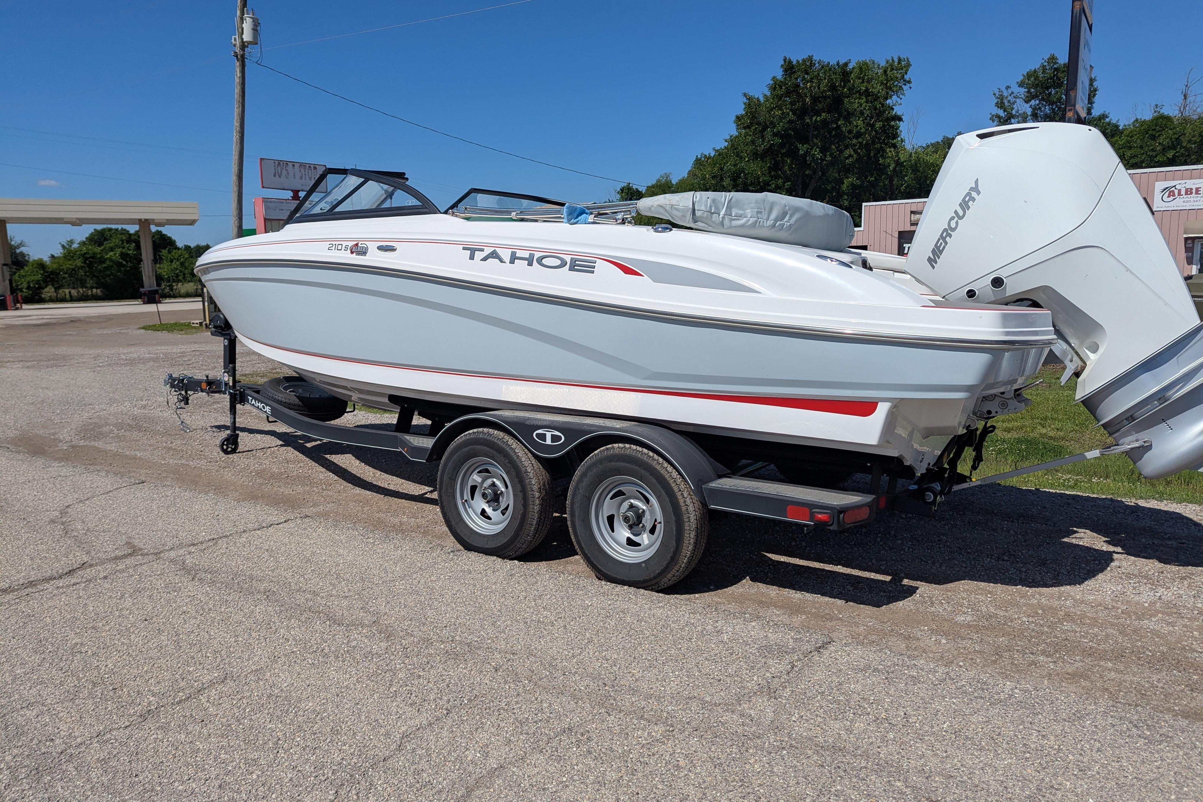 2022 Tahoe 210 S boat on trailer, parked outdoors, featuring a sleek white design.