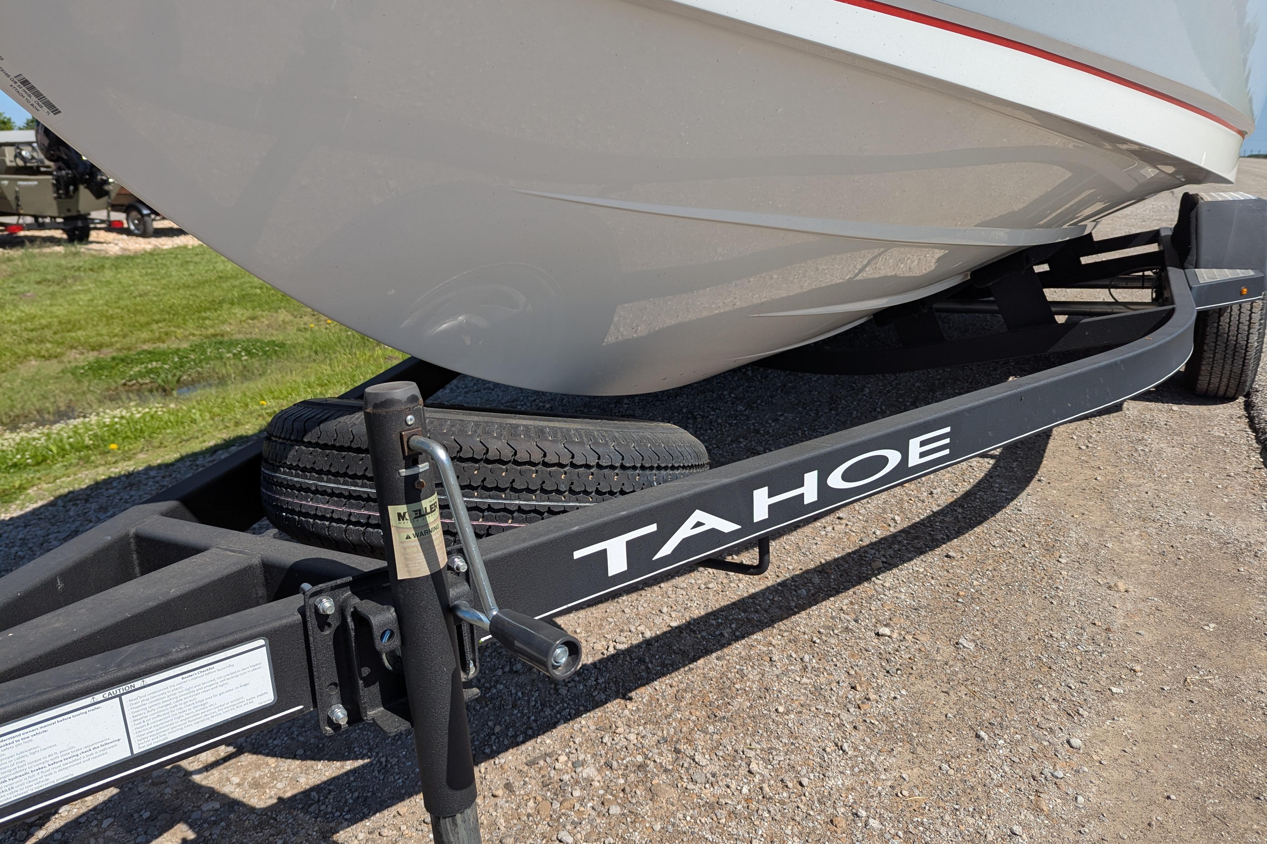 2022 Tahoe 210 S boat on trailer, parked on gravel, sunny day.