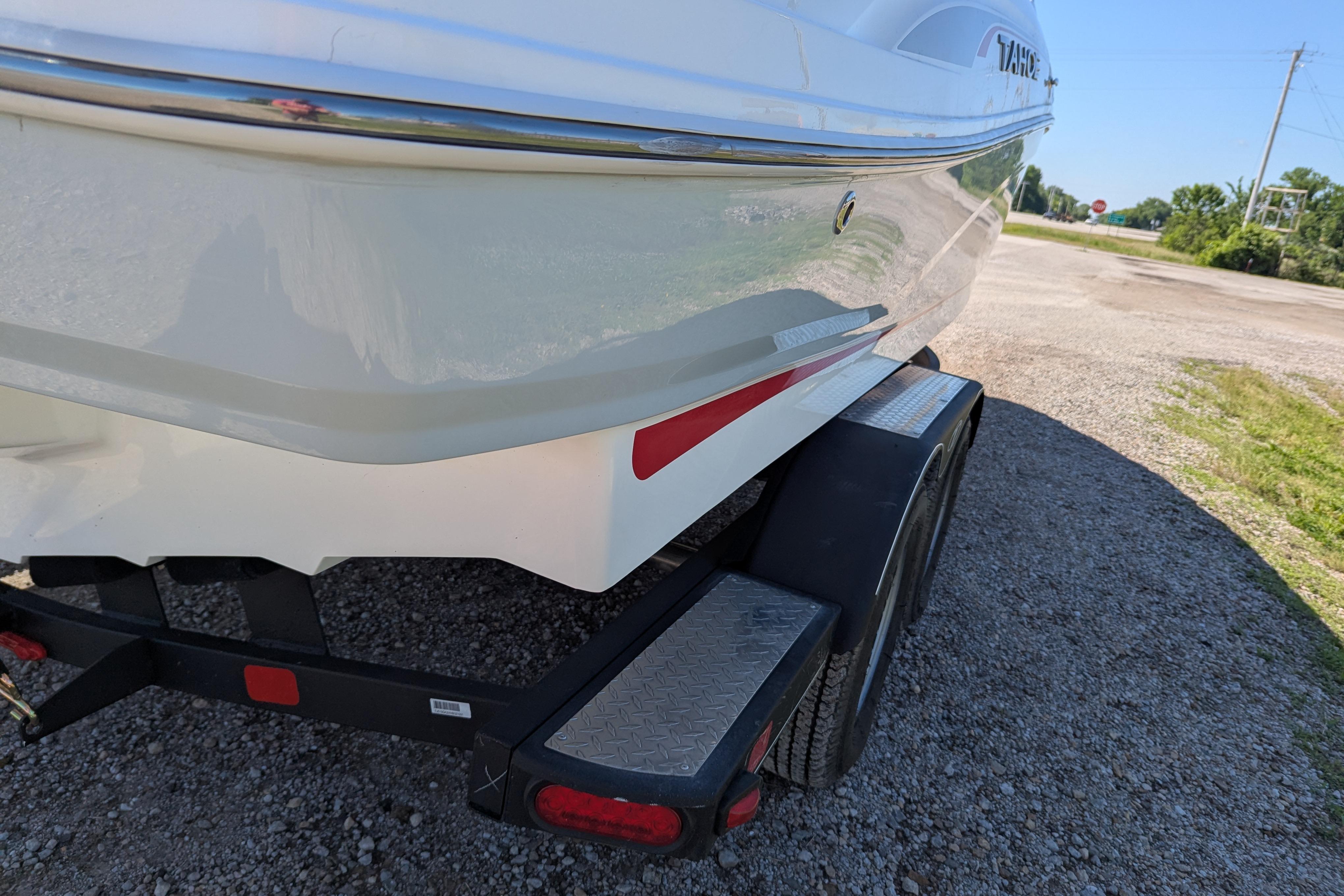 2022 Tahoe 210 S boat on trailer, parked on gravel road.