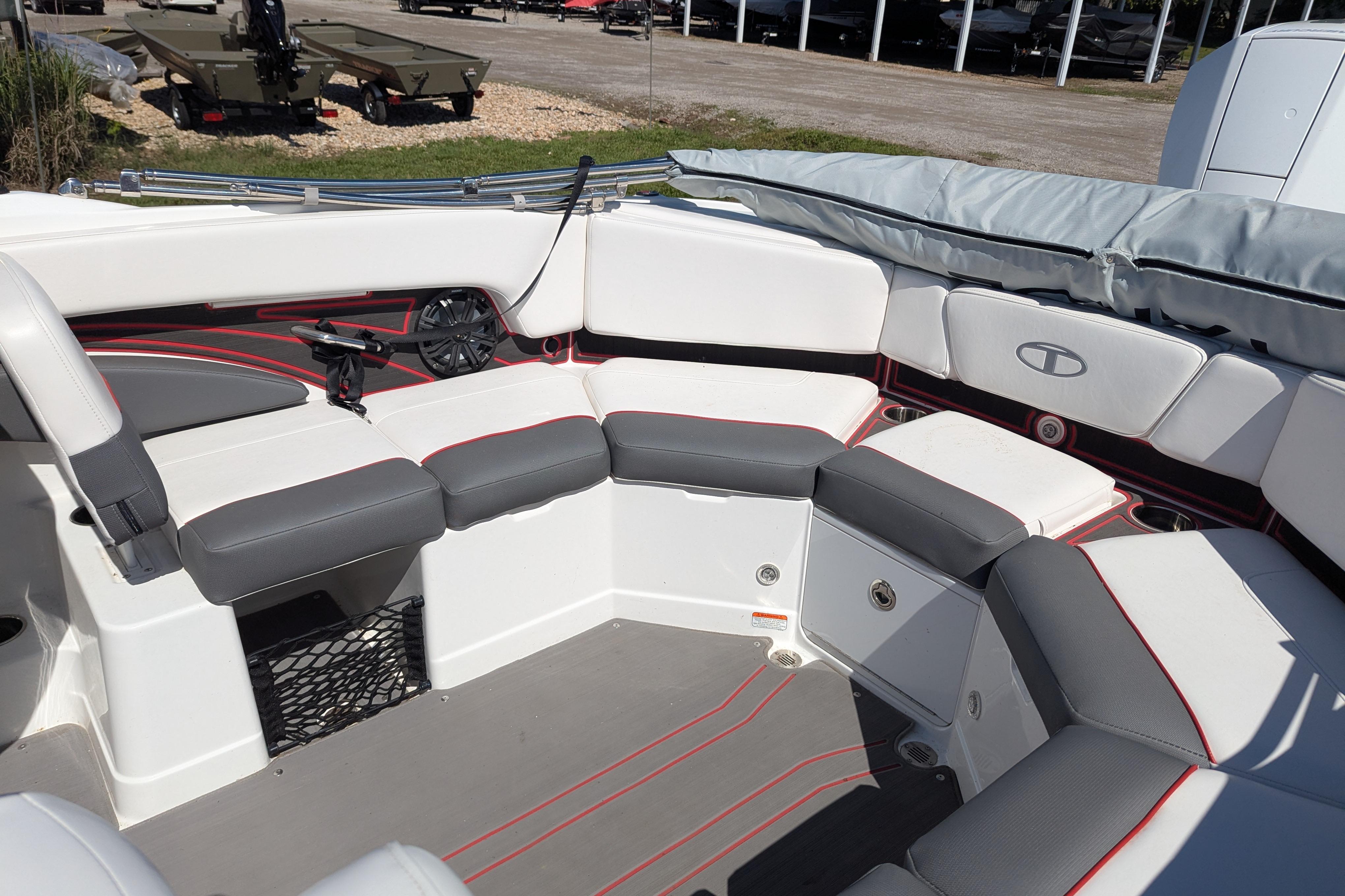 2022 Tahoe 210 S boat interior with gray and white seating, red accents, and storage compartments.