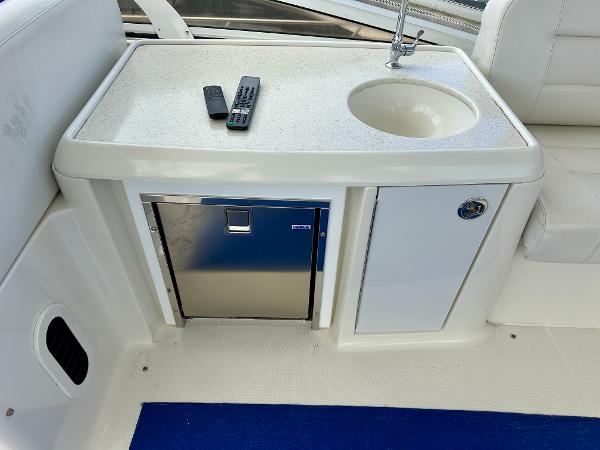 2008 Carver 43 Super Sport yacht interior with sink, mini fridge, and remote controls.