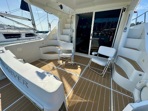 2008 Carver 43 Super Sport yacht deck with seating and stairs, docked at marina.