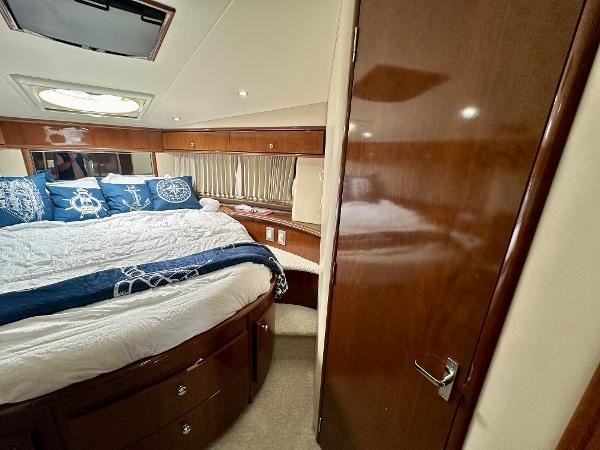 Luxurious bedroom interior of 2008 Carver 43 Super Sport yacht with elegant wood finishes.
