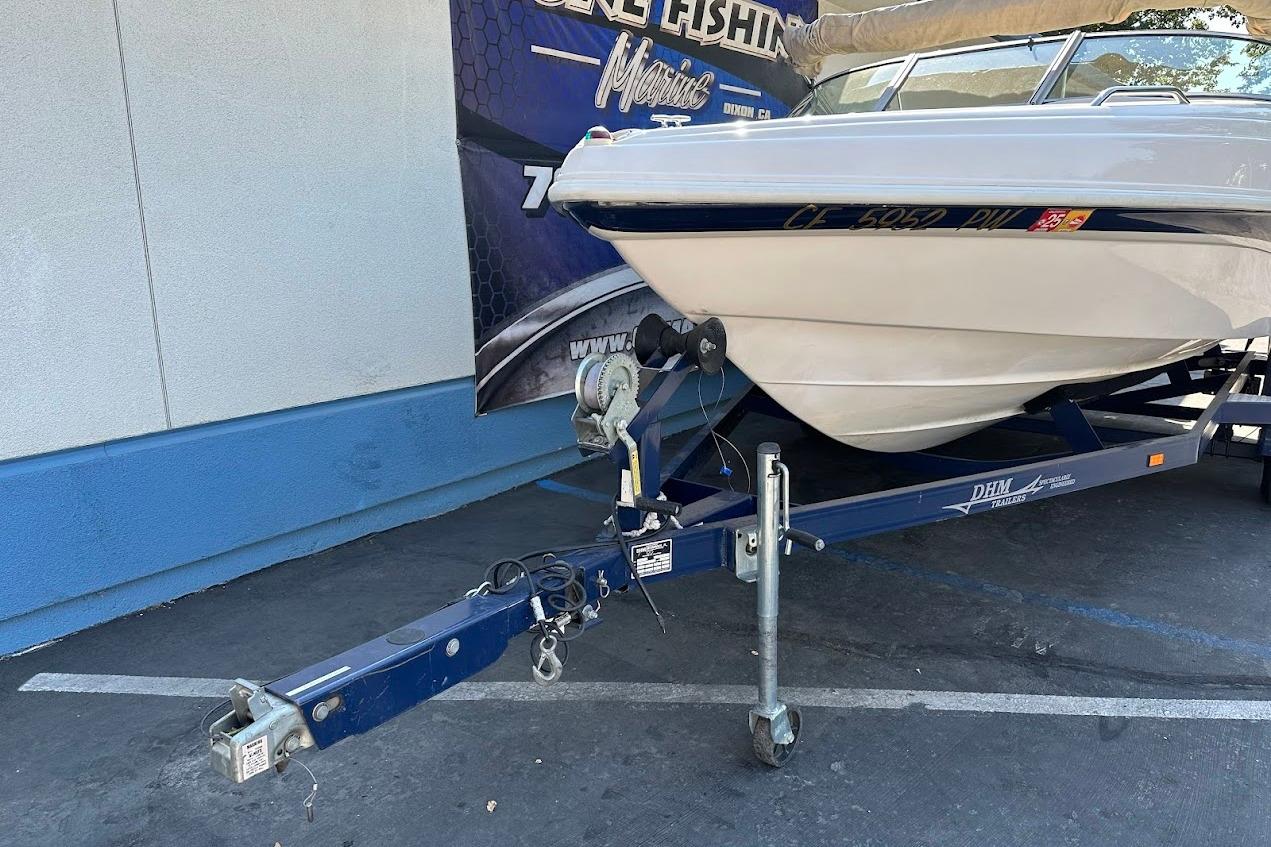 2002 Rinker 212 Captiva boat on trailer, parked outdoors.