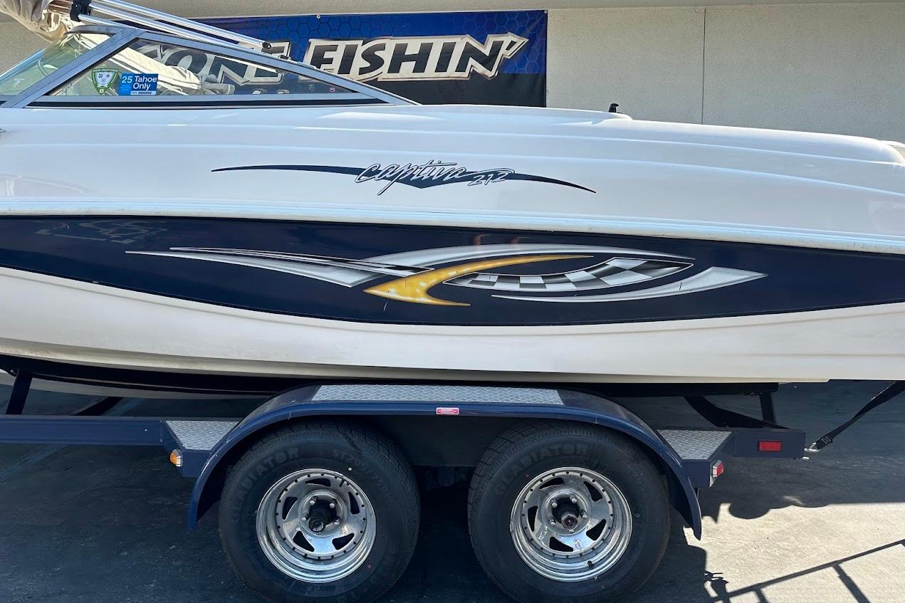 2002 Rinker 212 Captiva boat on trailer, featuring sleek design and vibrant graphics.