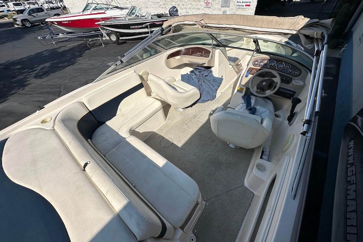 2002 Rinker 212 Captiva boat interior with beige seating and steering wheel.
