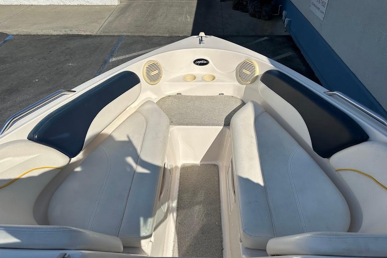 2002 Rinker 212 Captiva boat interior with cushioned seating and speakers.