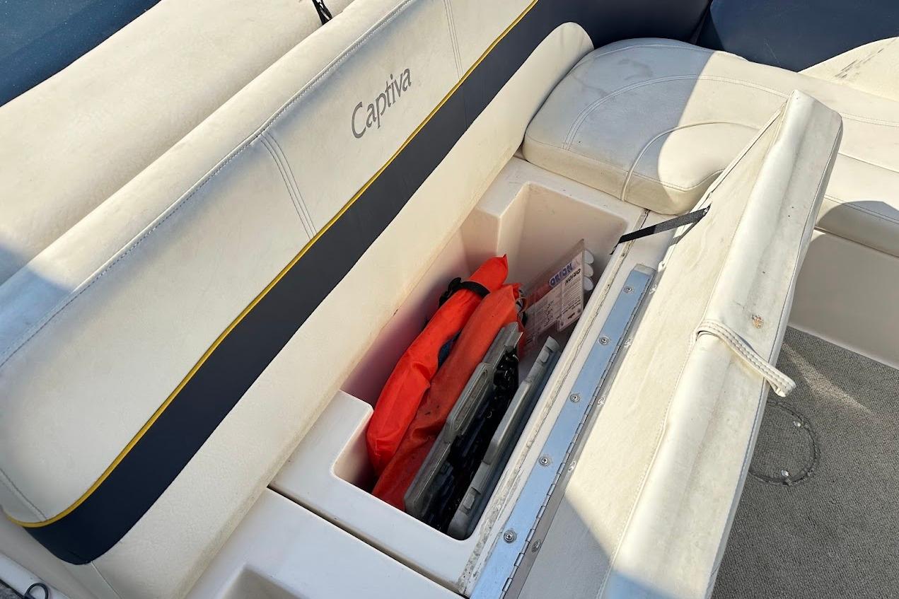 2002 Rinker 212 Captiva boat seat storage with life jacket and accessories.