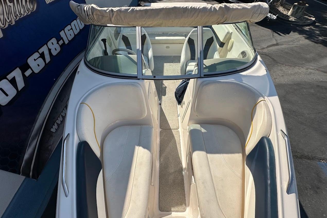 2002 Rinker 212 Captiva boat interior with seating and windshield, parked outdoors.
