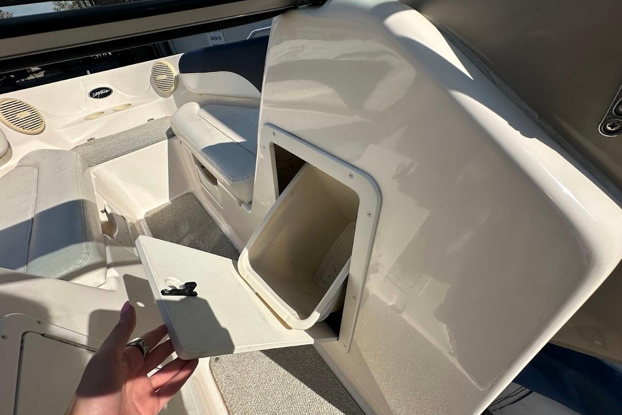 2002 Rinker 212 Captiva boat interior with open storage compartment and seating area.