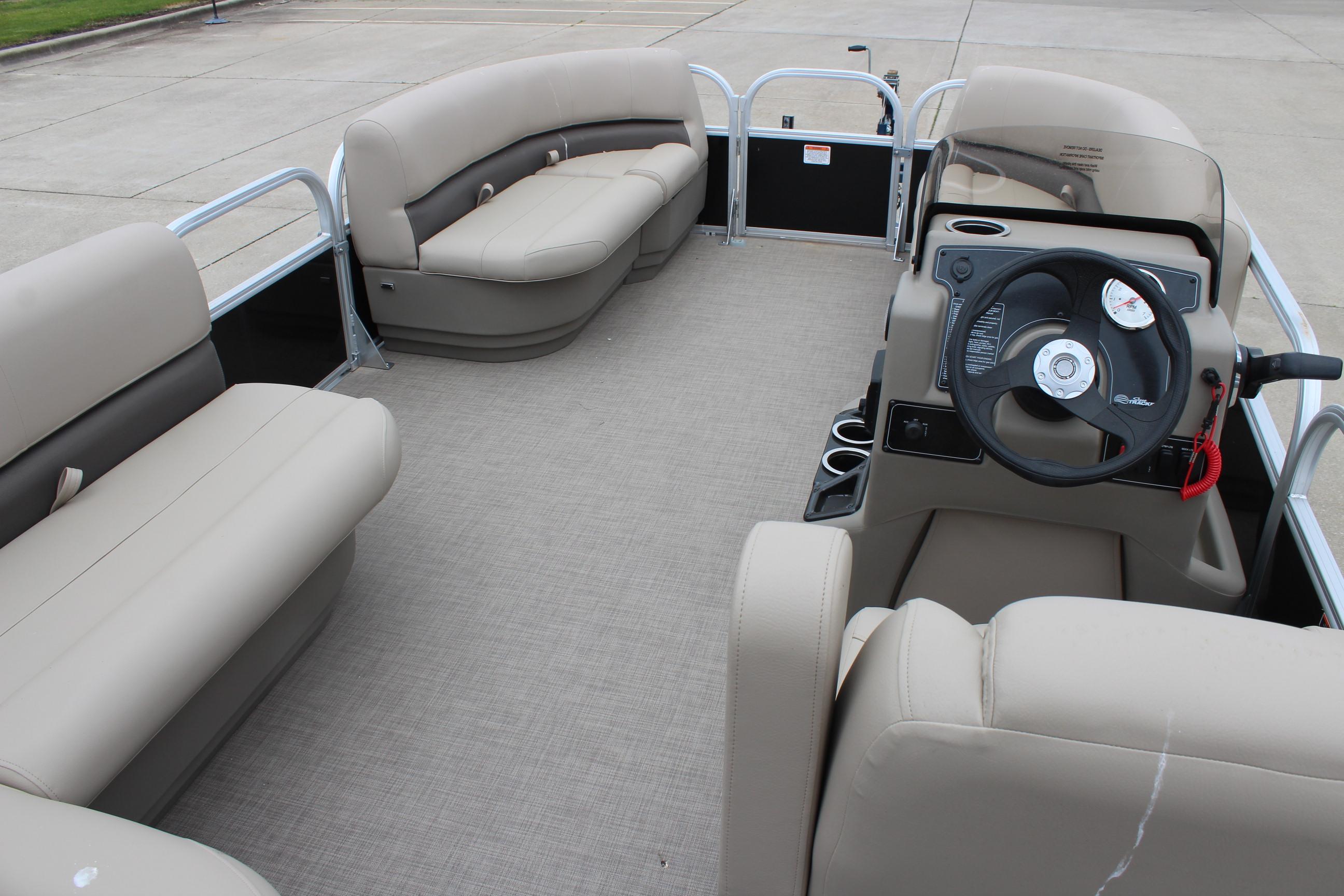 2025 Sun Tracker Party Barge 16 DLX interior with beige seating and steering console.