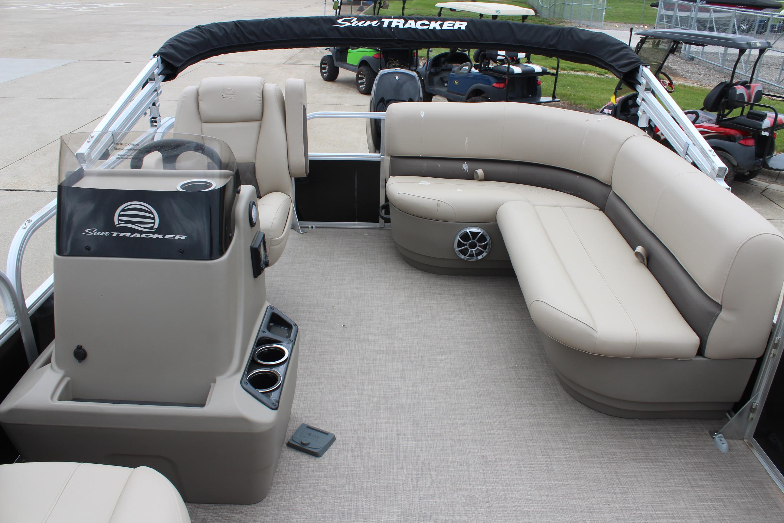 2025 Sun Tracker Party Barge 16 DLX interior with beige seating and steering console.