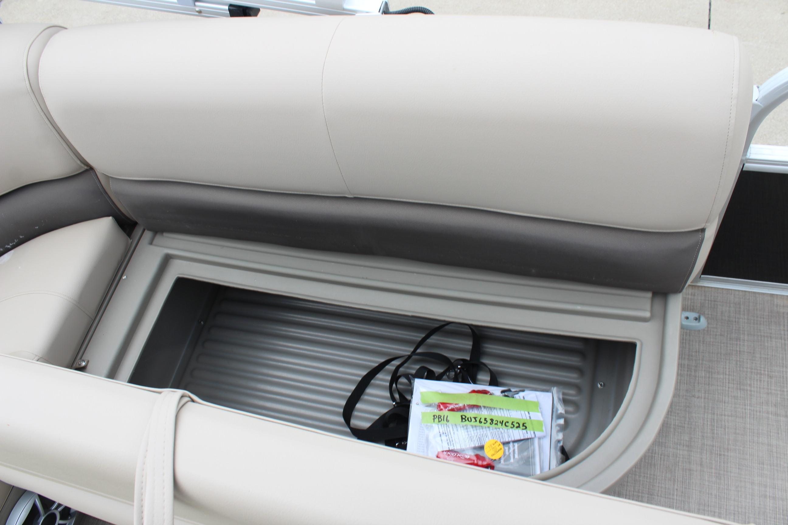 2025 Sun Tracker Party Barge 16 DLX storage compartment with beige seating and accessories.
