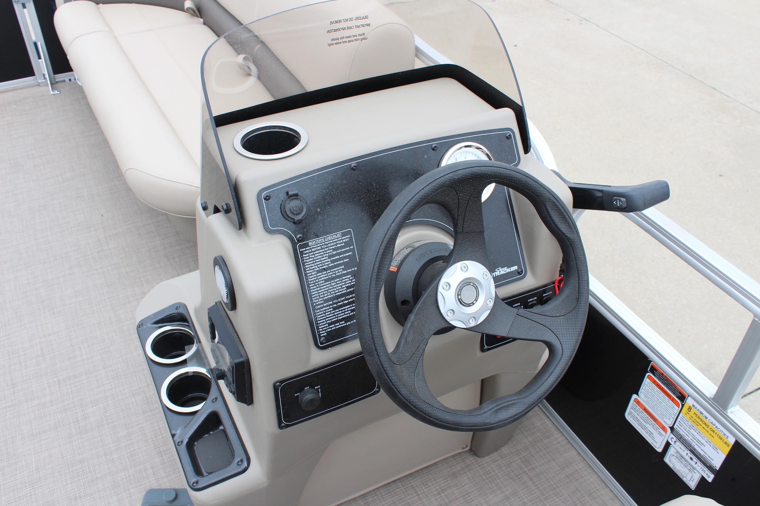 2025 Sun Tracker Party Barge 16 DLX steering console with cup holders and controls.