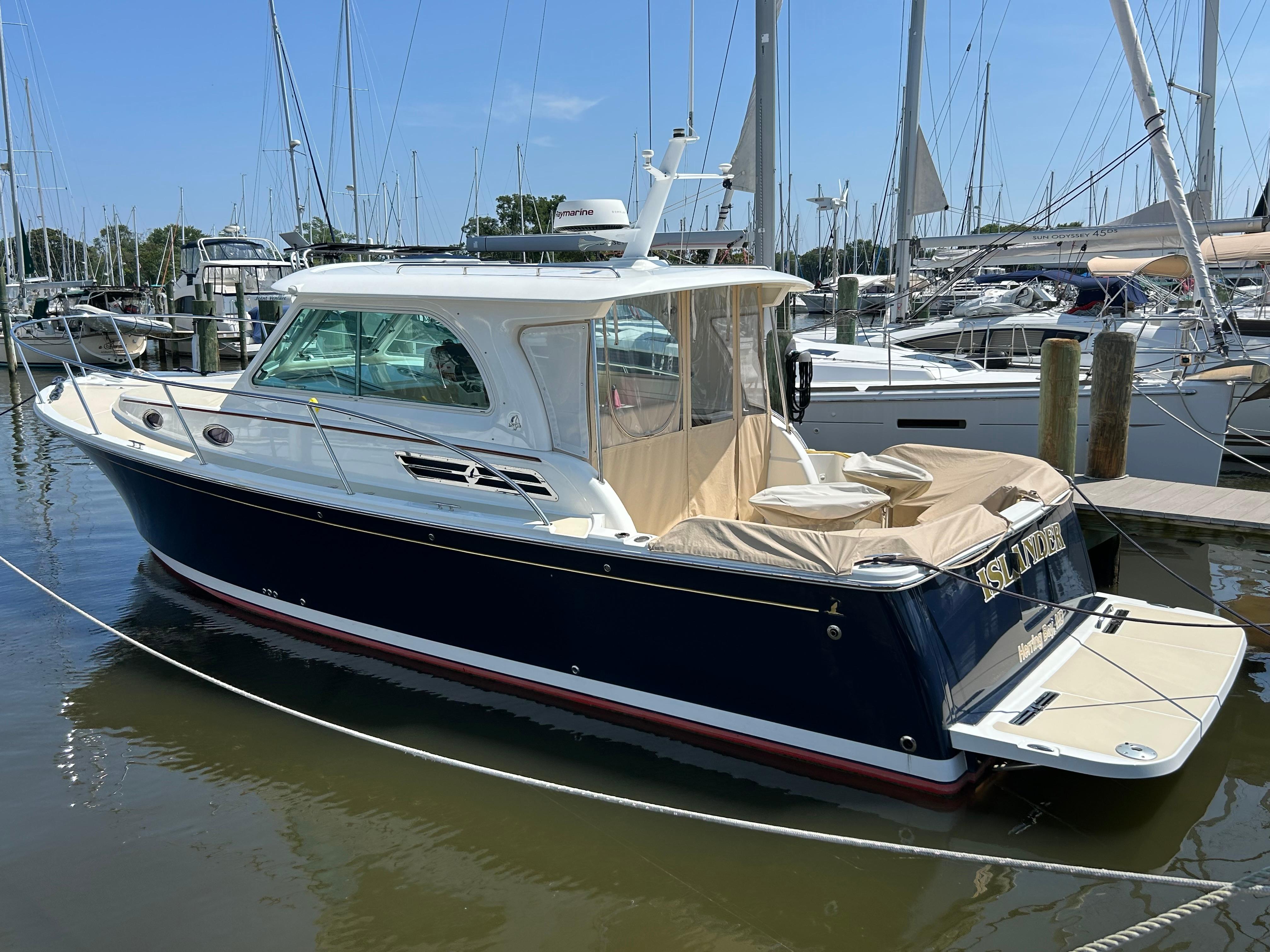 2018 Back Cove 32 boat docked in a marina, featuring a sleek design and spacious deck.