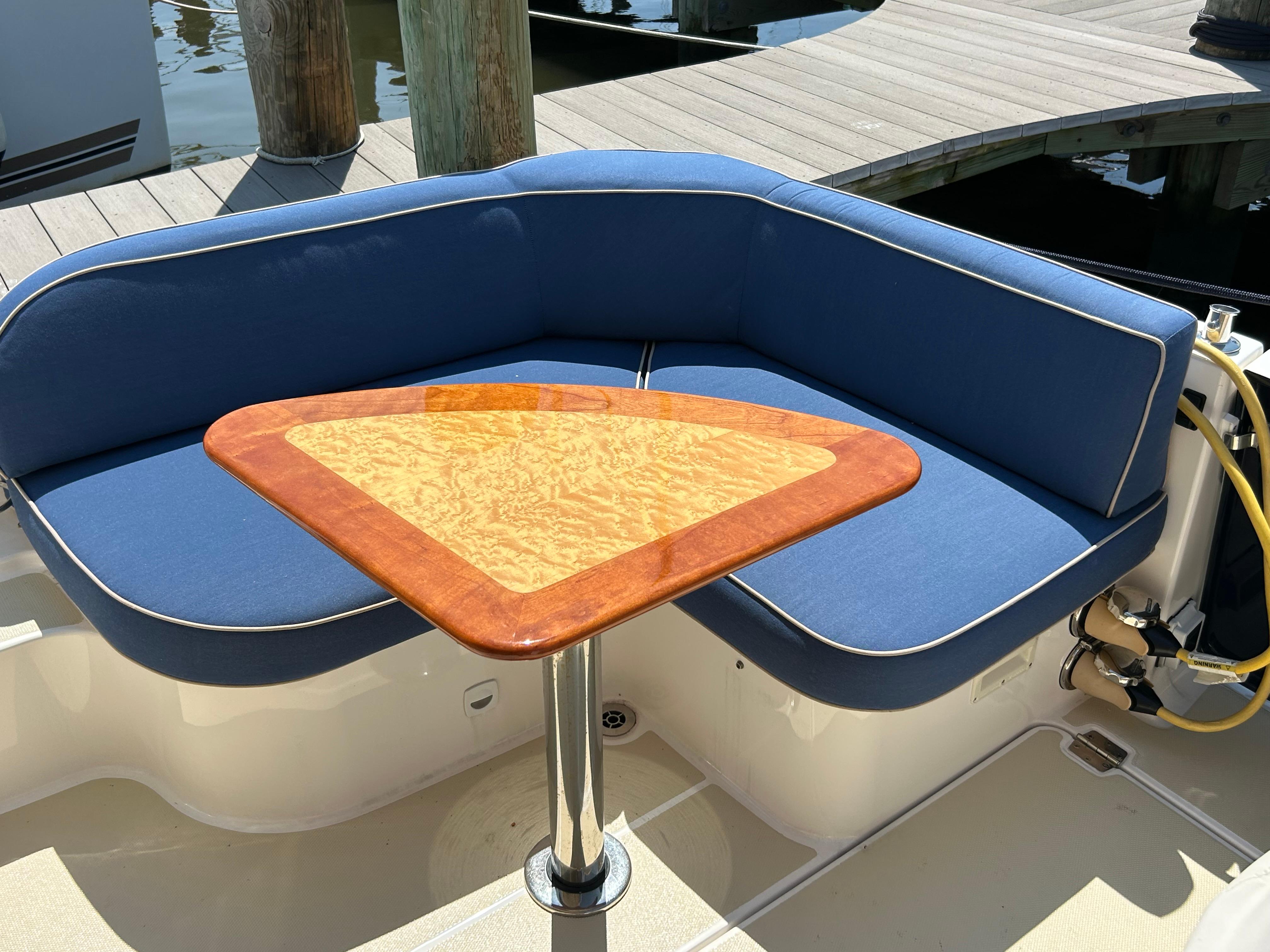 2018 Back Cove 32 boat with blue seating and a wooden table on deck.