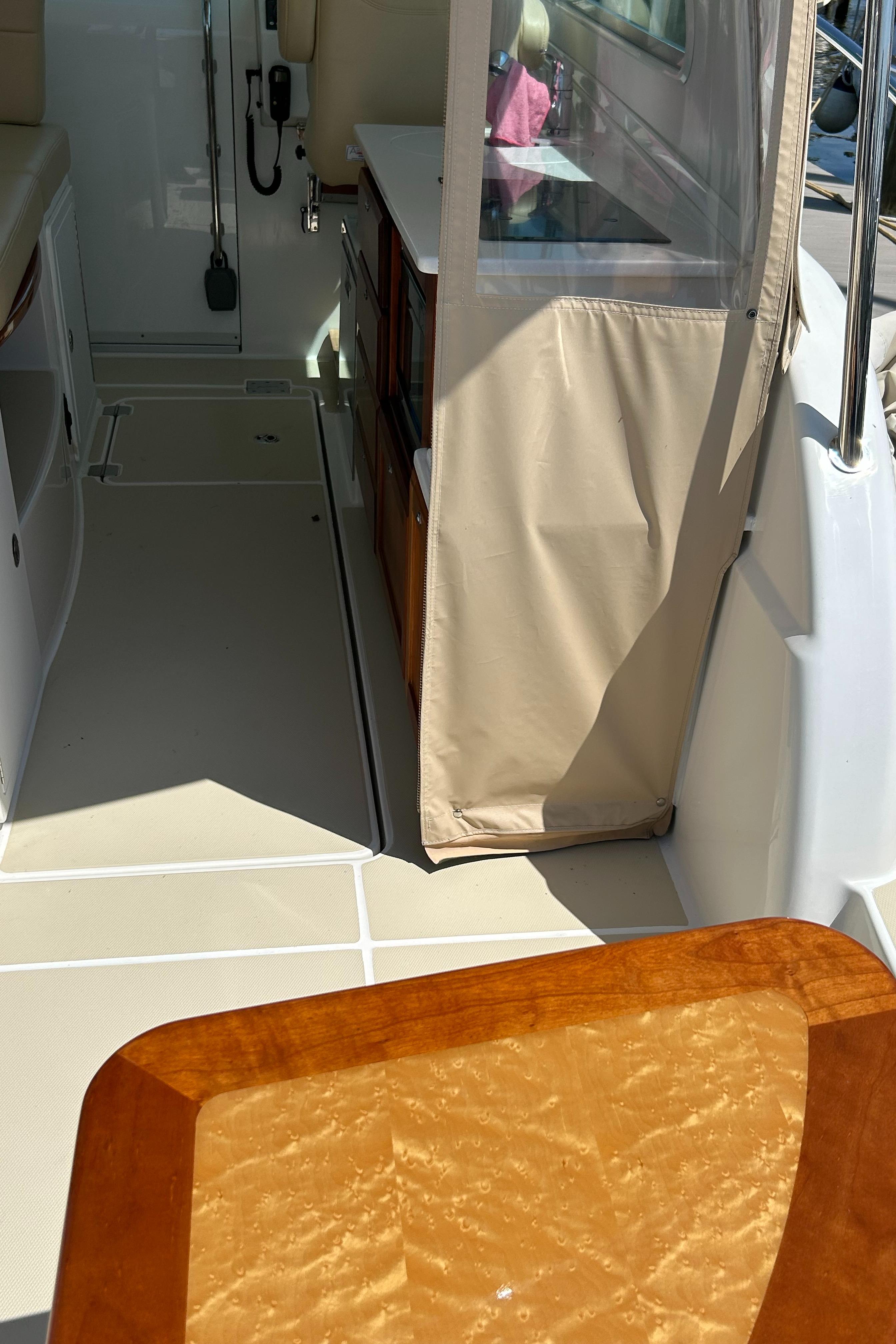 2018 Back Cove 32 interior with beige seating, wooden table, and storage cabinets.