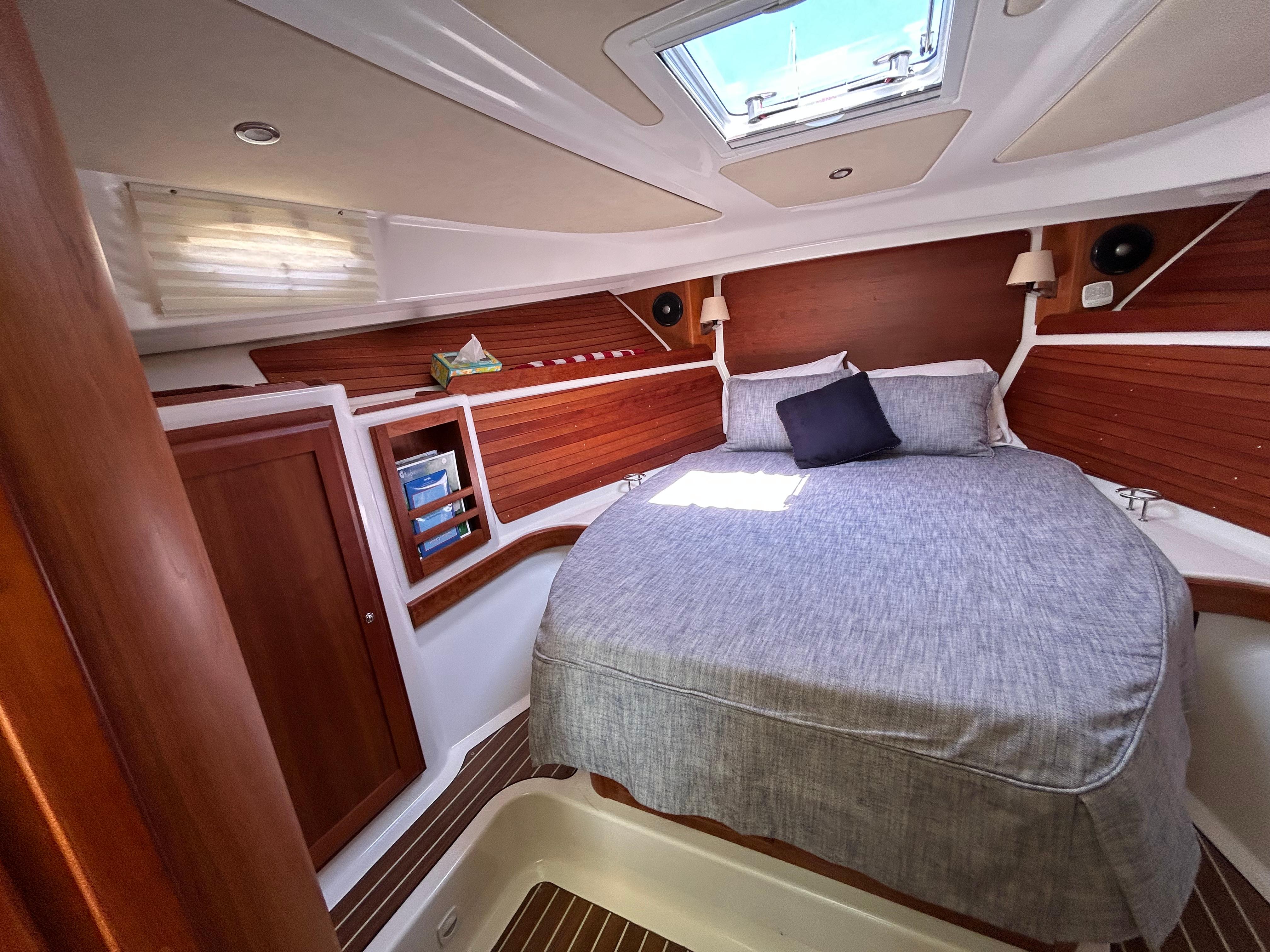 Luxurious cabin interior of 2018 Back Cove 32 yacht with cozy bed and wooden accents.