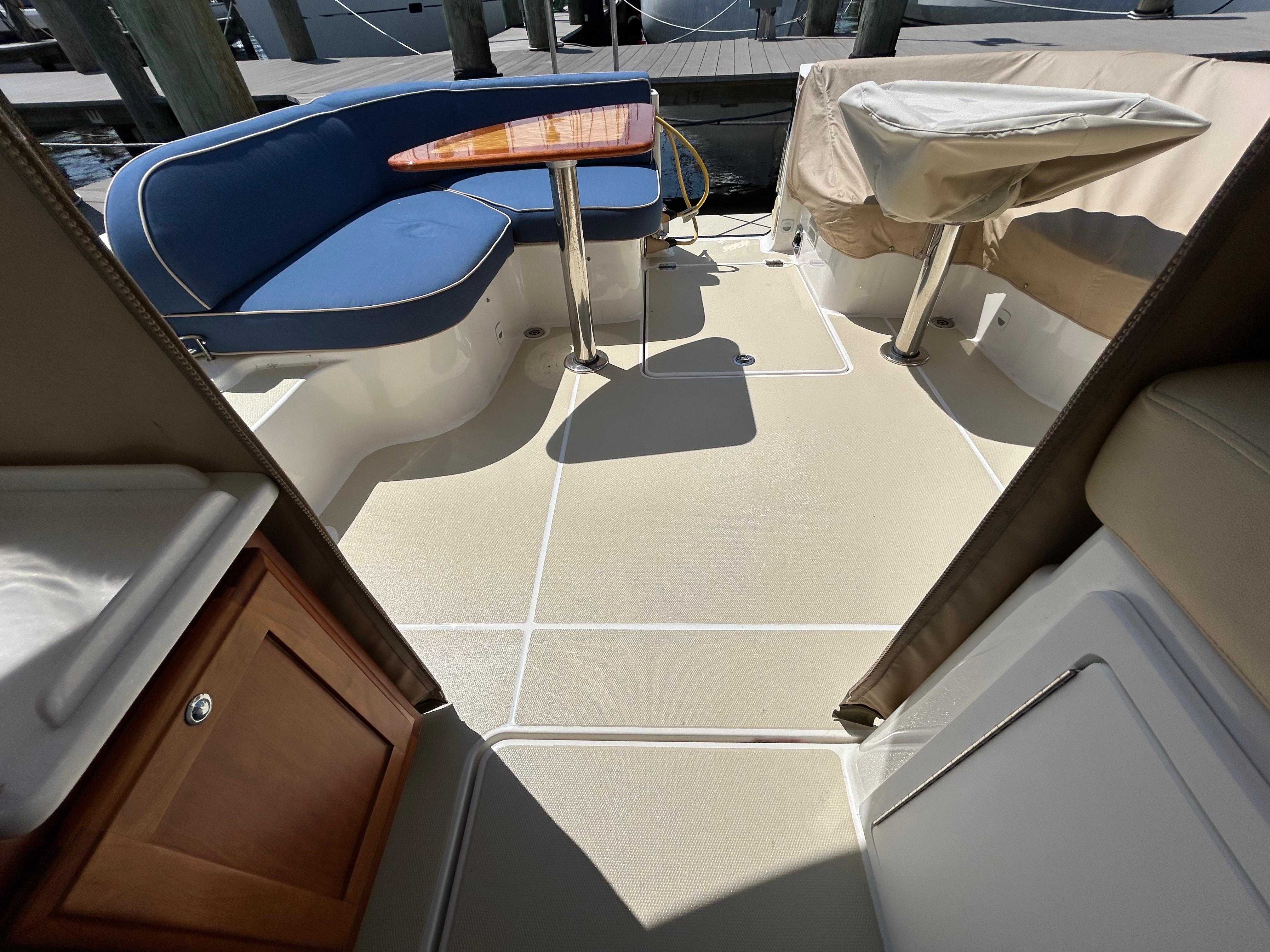 2018 Back Cove 32 boat interior with blue seating and wooden table.