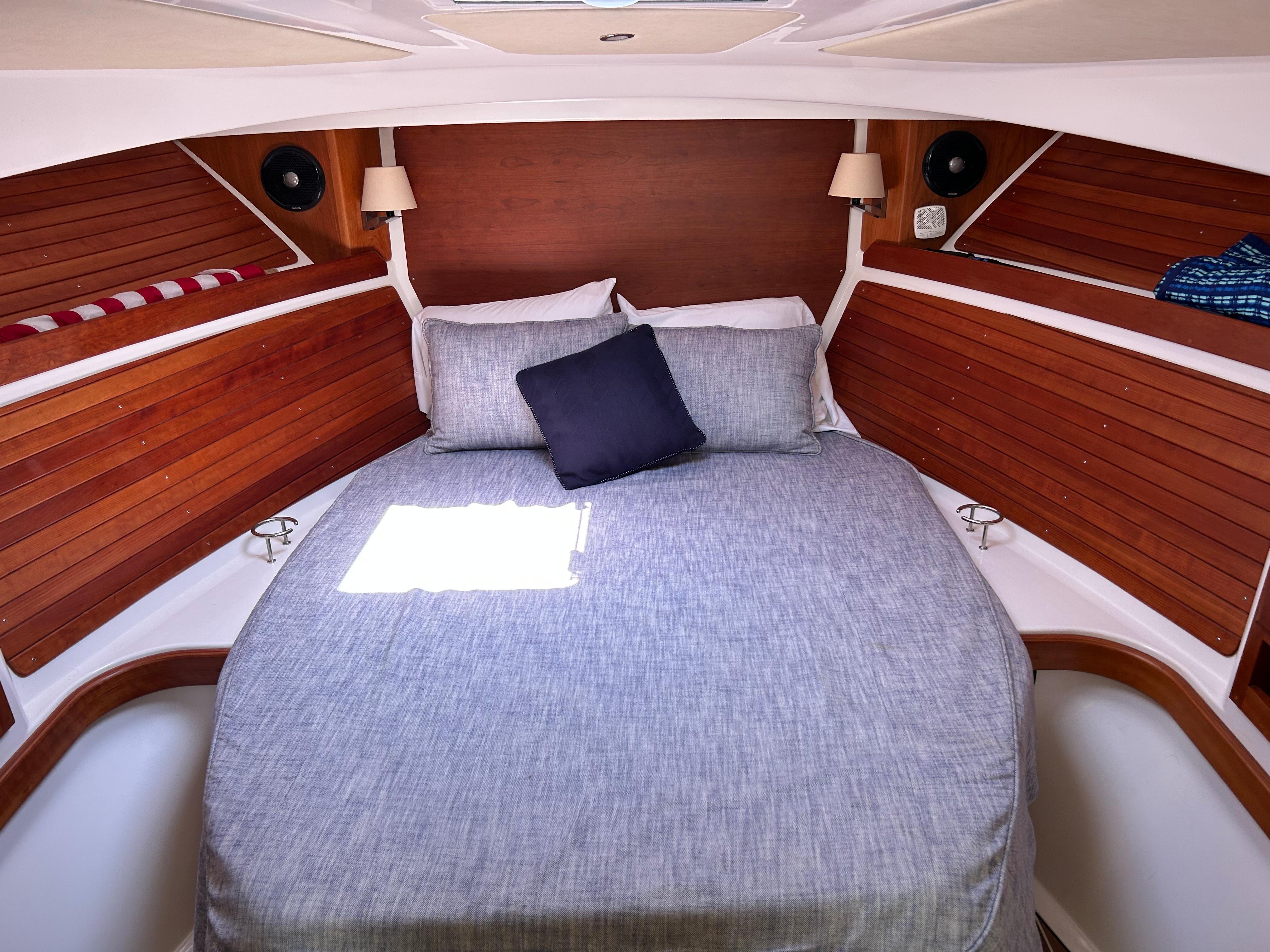 Cozy cabin interior of 2018 Back Cove 32 with wooden accents and comfortable bedding.