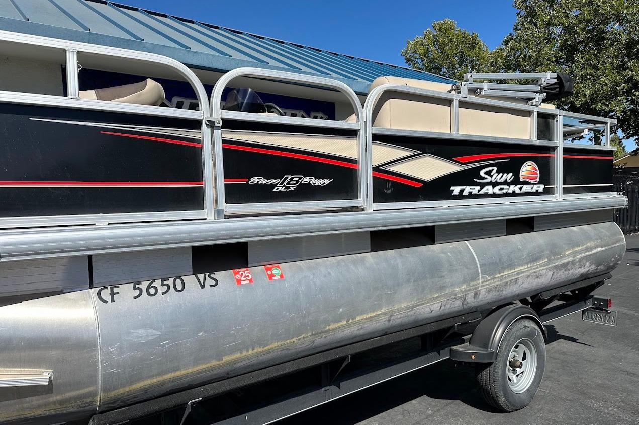 2019 Sun Tracker Bass Buggy 18 DLX pontoon boat on trailer, side view.