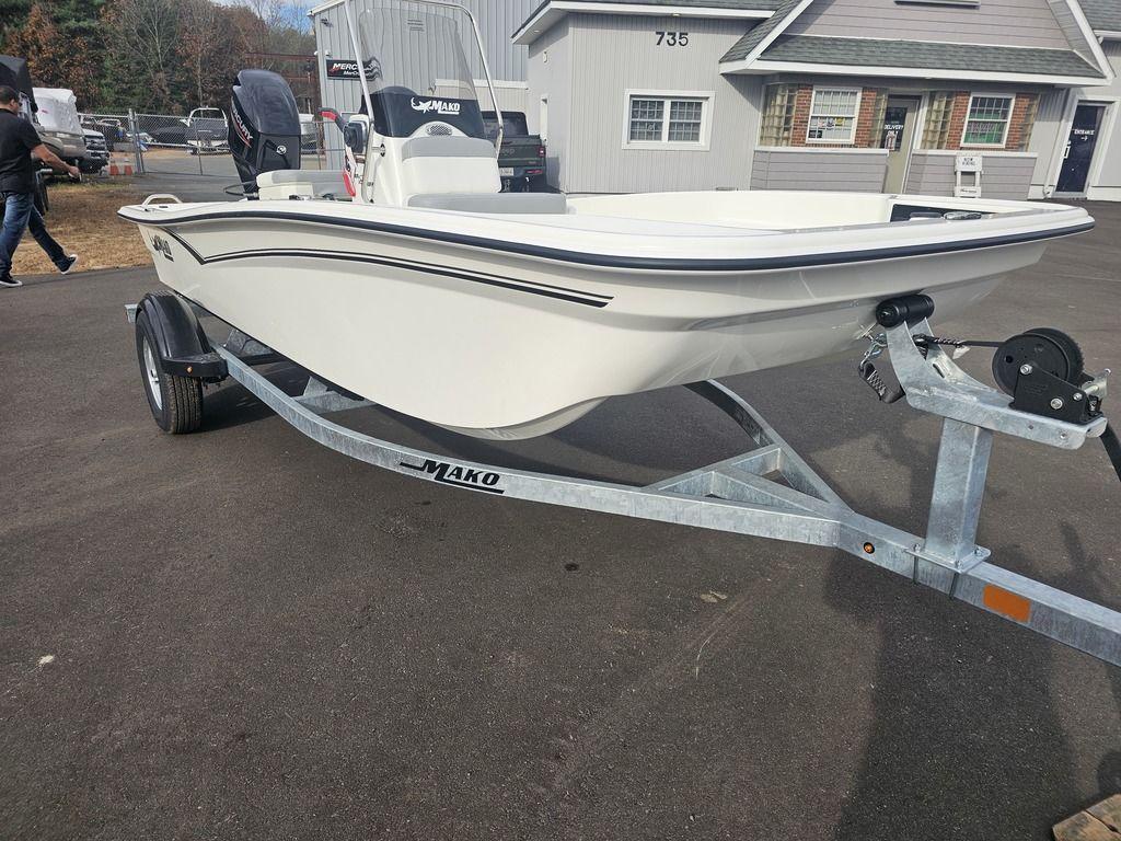 2025 Mako Pro Skiff 15 CC boat on trailer, parked outside a building.