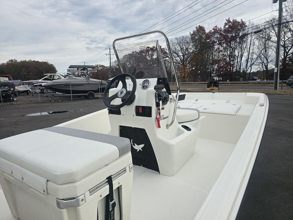 2025 Mako Pro Skiff 15 CC boat with center console and seating, parked outdoors.