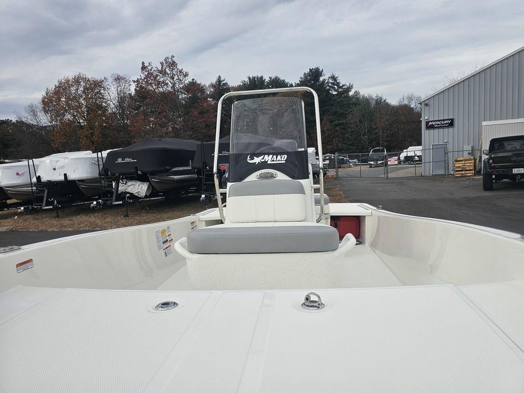2025 Mako Pro Skiff 15 CC boat in a marina, surrounded by trees and buildings.
