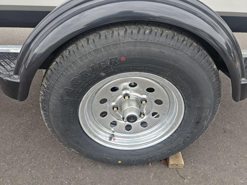 Trailer wheel of 2025 Mako Pro Skiff 15 CC on pavement.